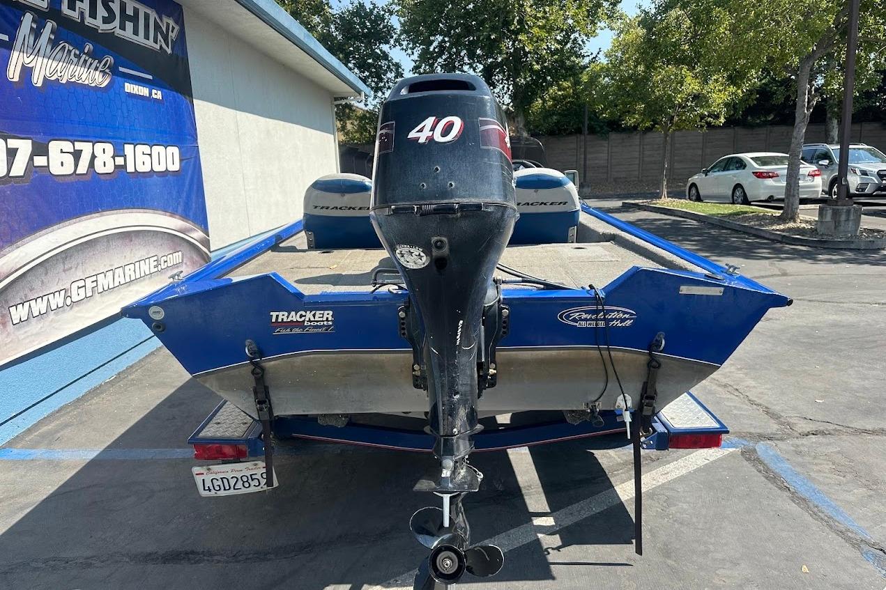 2005 Bass Tracker Pro Team 175 boat with outboard motor in parking lot.