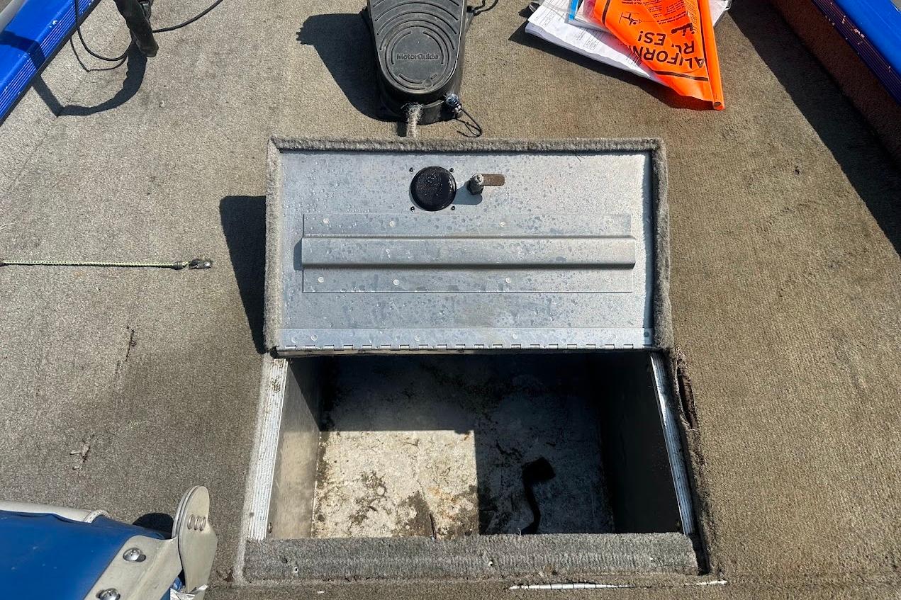Open storage compartment on a 2005 Bass Tracker Pro Team 175 boat deck.