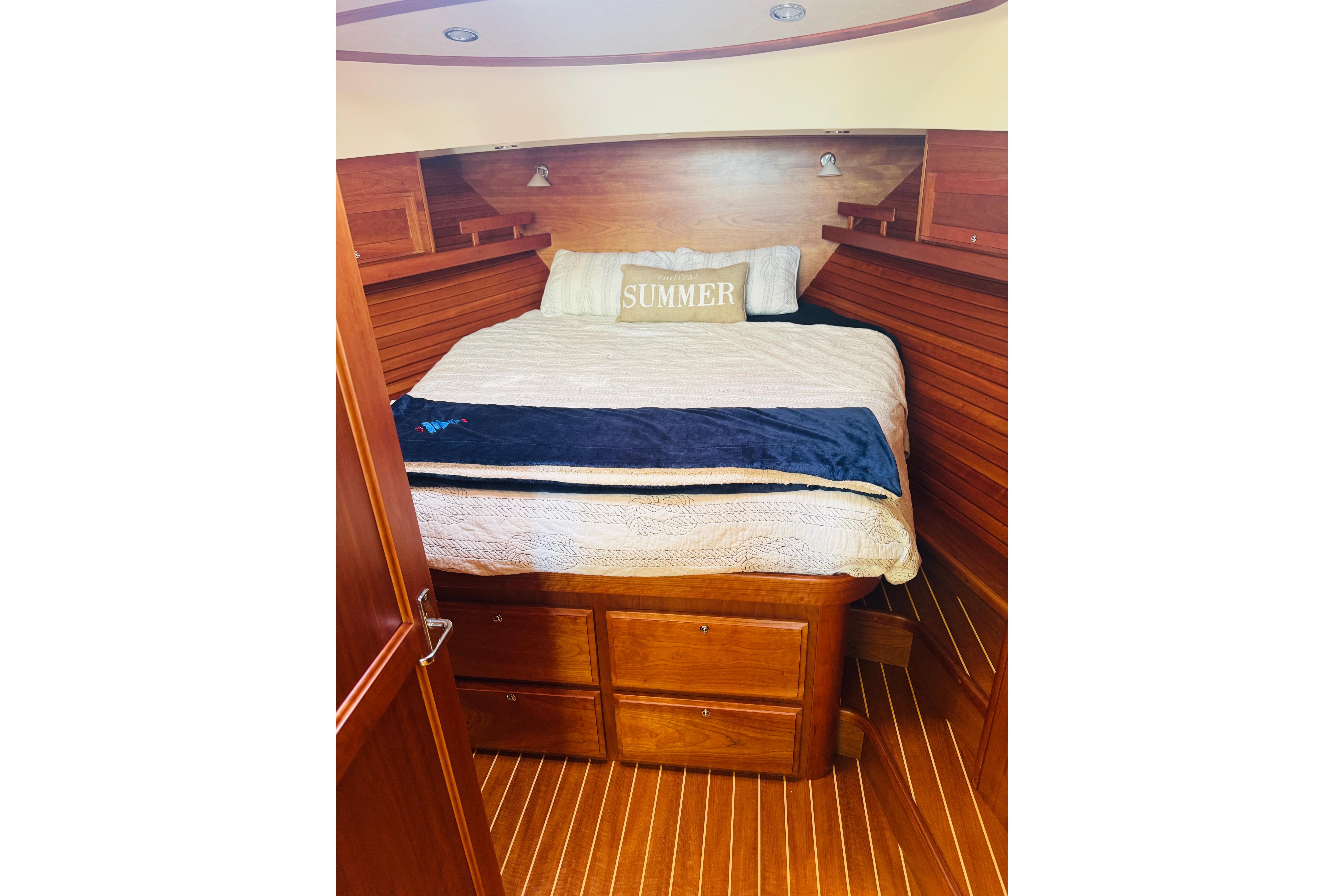 Cozy cabin interior of 2015 Sabre 38 Salon Express with wooden finish and comfortable bedding.