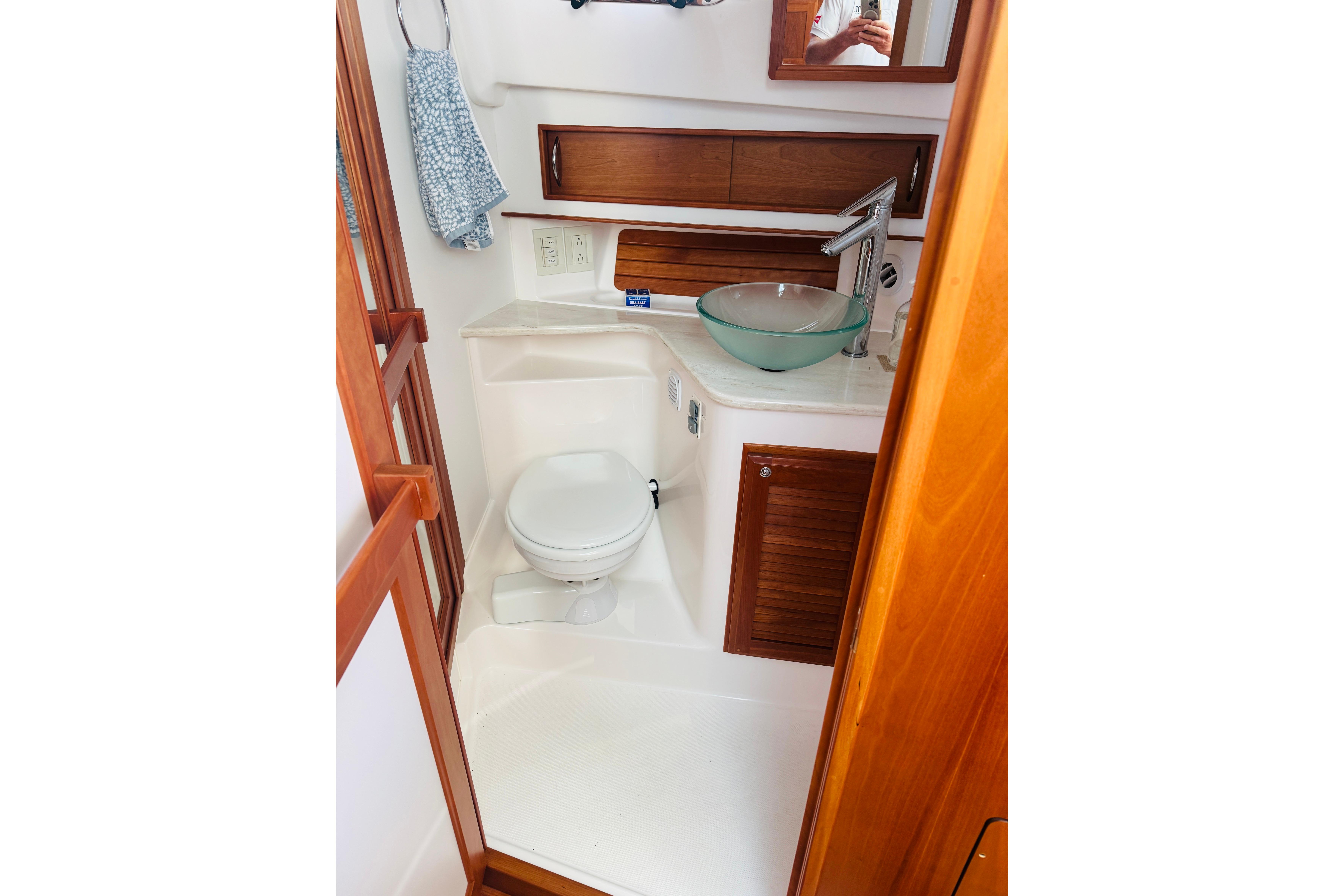 2015 Sabre 38 Salon Express bathroom with glass sink and wooden accents.