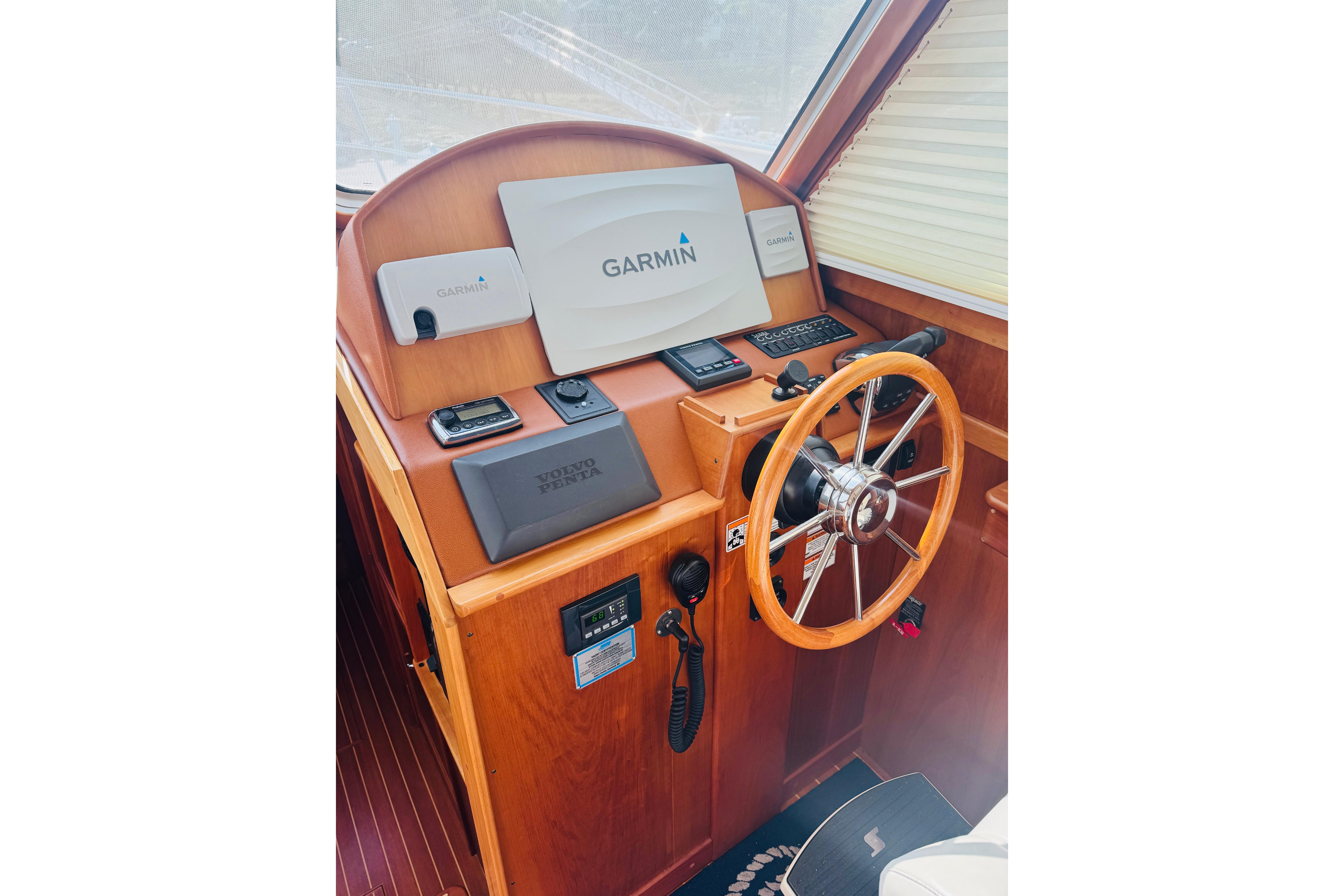 2015 Sabre 38 Salon Express helm with Garmin navigation and wooden steering wheel.