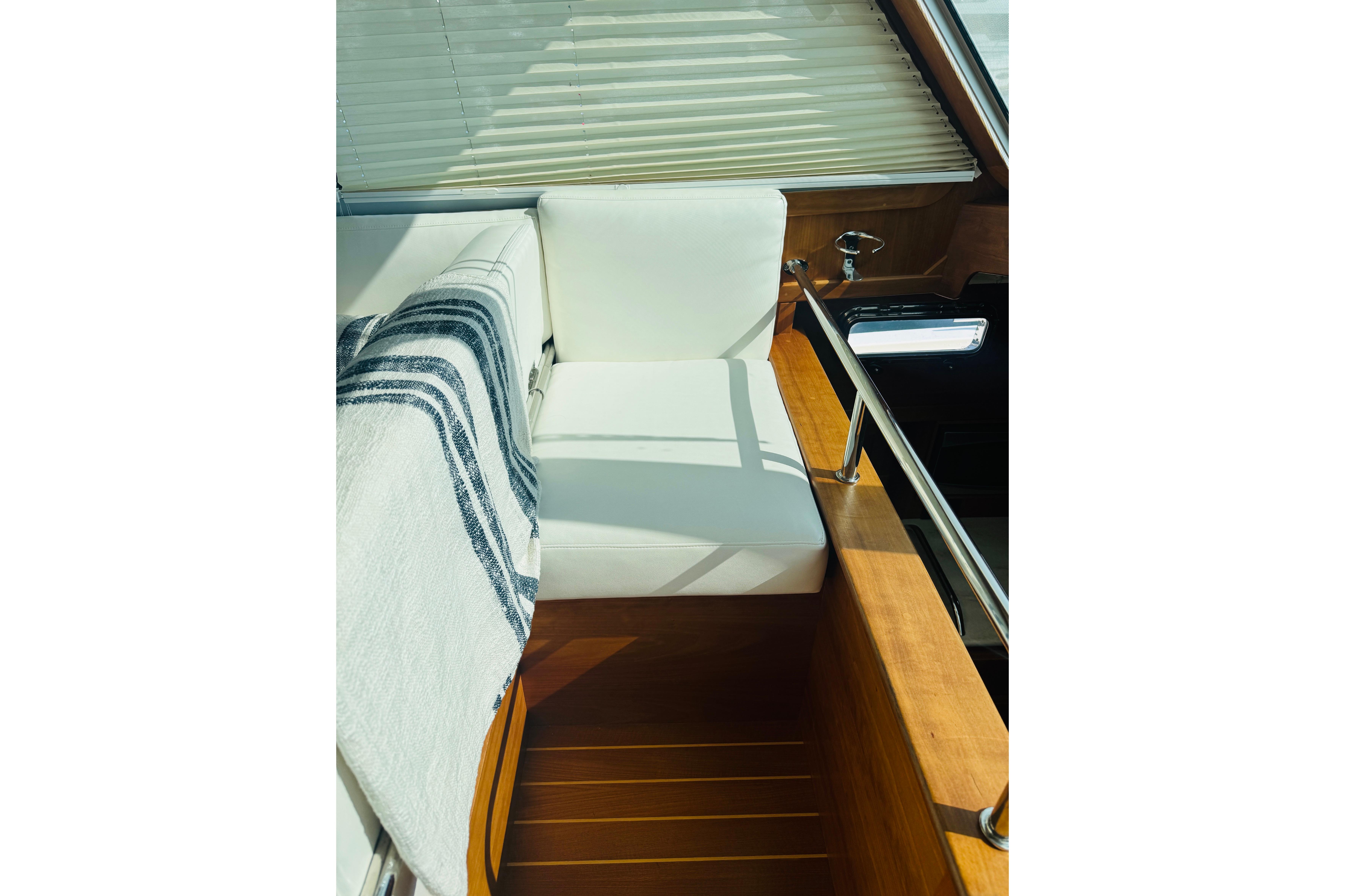 Interior of 2015 Sabre 38 Salon Express with white seating and striped blanket.