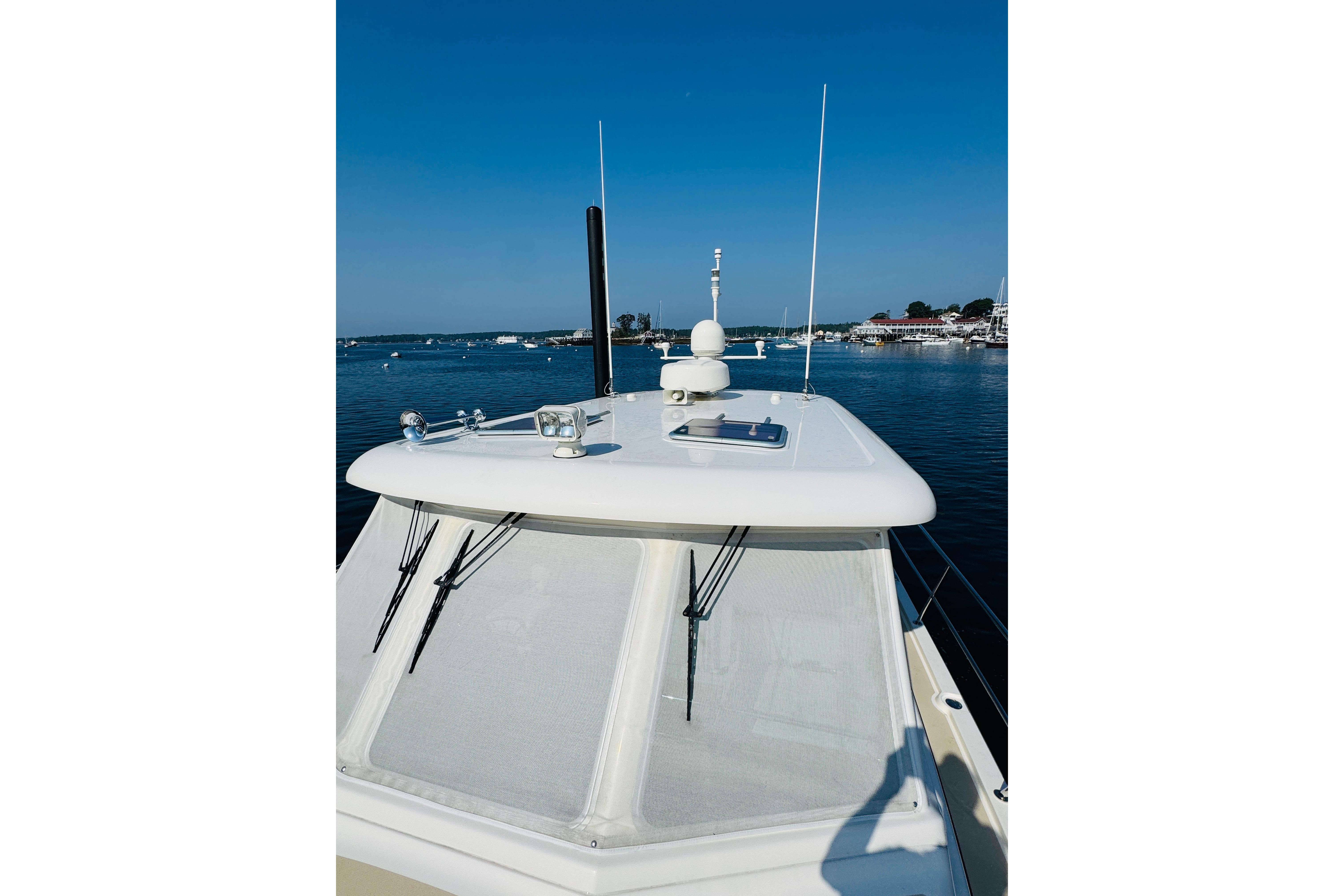 2015 Sabre 38 Salon Express yacht on calm water, clear blue sky background.