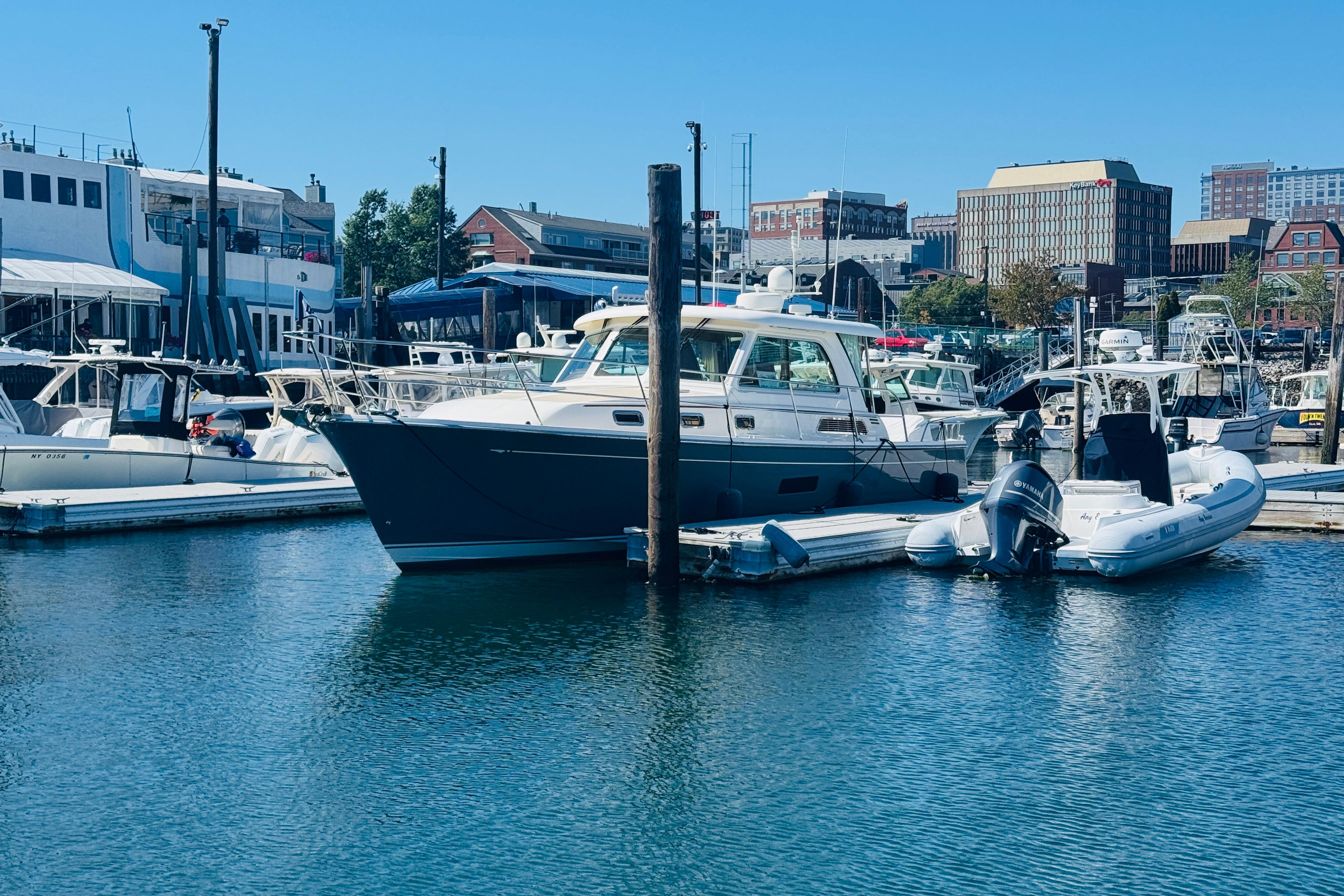 2015 Sabre 38 Salon Express yacht docked in a bustling marina.