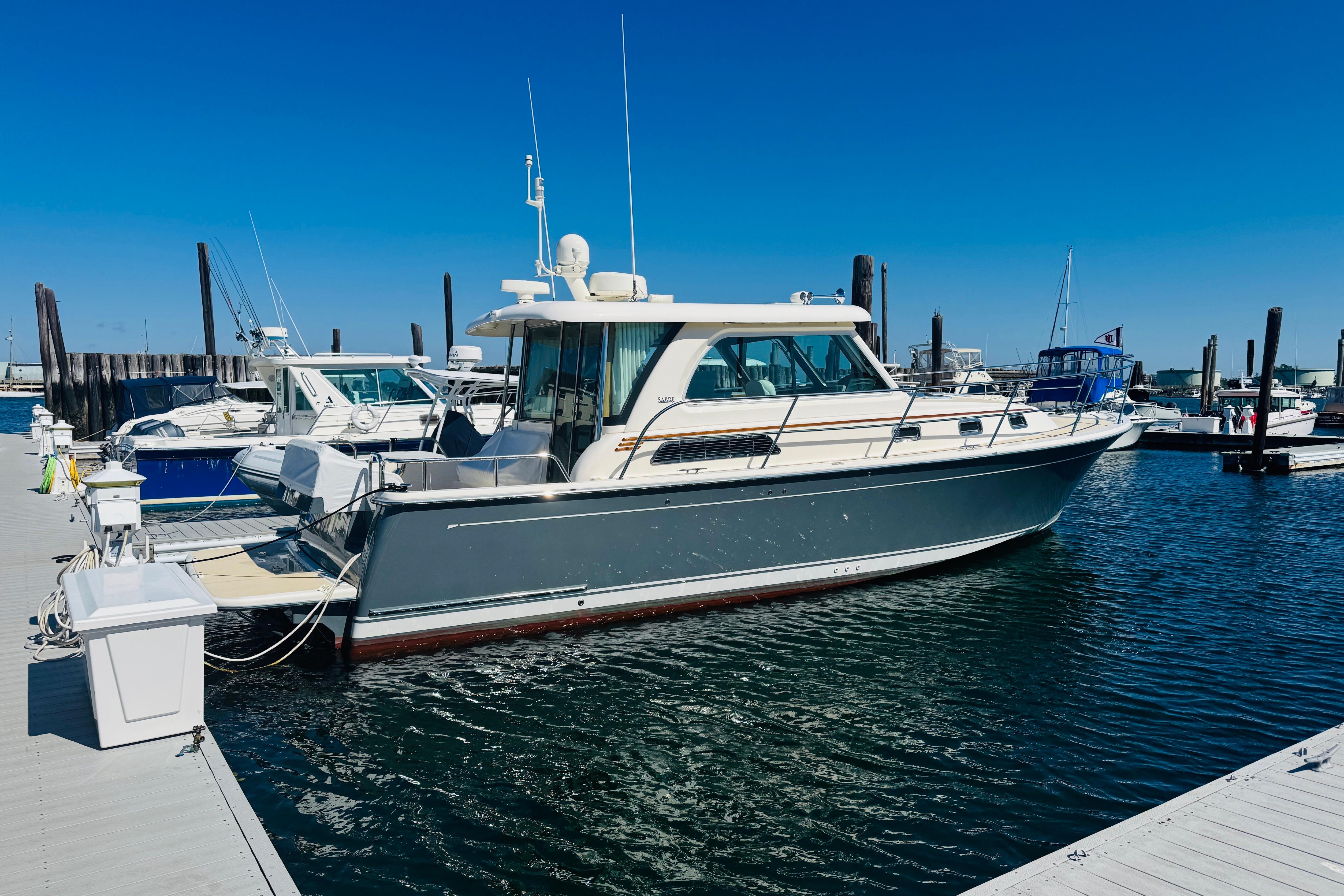 2015 Sabre 38 Salon Express yacht docked at marina under clear blue sky.