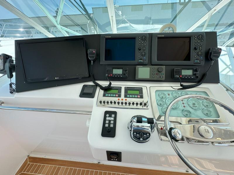 Cabo-Express 2004-TUNA DAZE MA-US-Control panel of a 2004 Cabo Express boat with navigation screens and steering wheel.-5384122 | Thumbnail