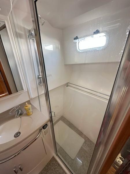 Cabo-Express 2004-TUNA DAZE MA-US-2004 Cabo Express boat bathroom with shower, sink, and window.-5384122 | Thumbnail