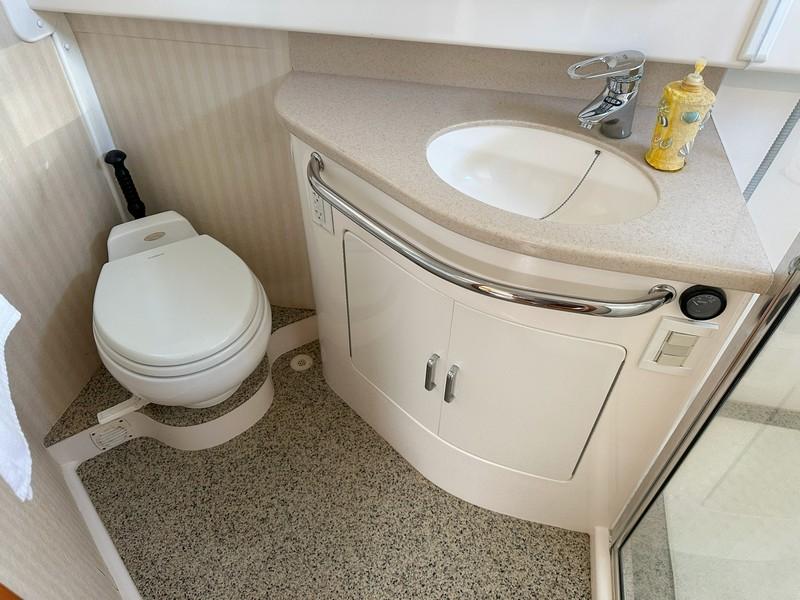 Cabo-Express 2004-TUNA DAZE MA-US-Compact bathroom in a 2004 Cabo Express boat with sink and toilet.-5384122 | Thumbnail