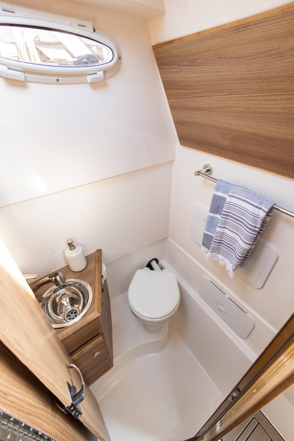 Solara-S-310 CW 2025 -FL-US-Compact bathroom in 2025 Solara S-310 CW boat with modern fixtures and wood accents.-9624144 | Thumbnail