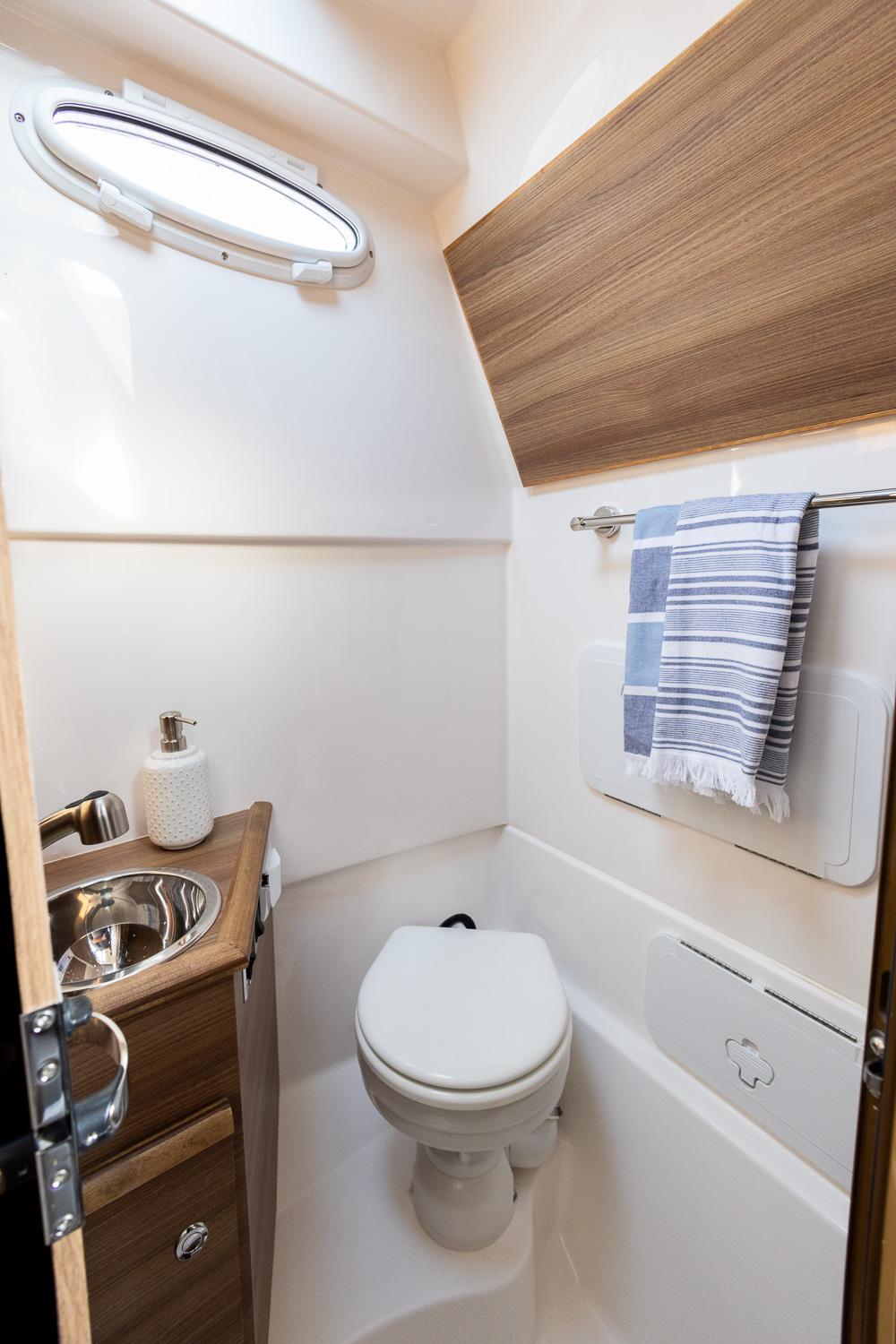 Solara-S-310 CW 2025 -FL-US-Compact bathroom in 2025 Solara S-310 CW boat with modern fixtures and wood accents.-9624144 | Thumbnail