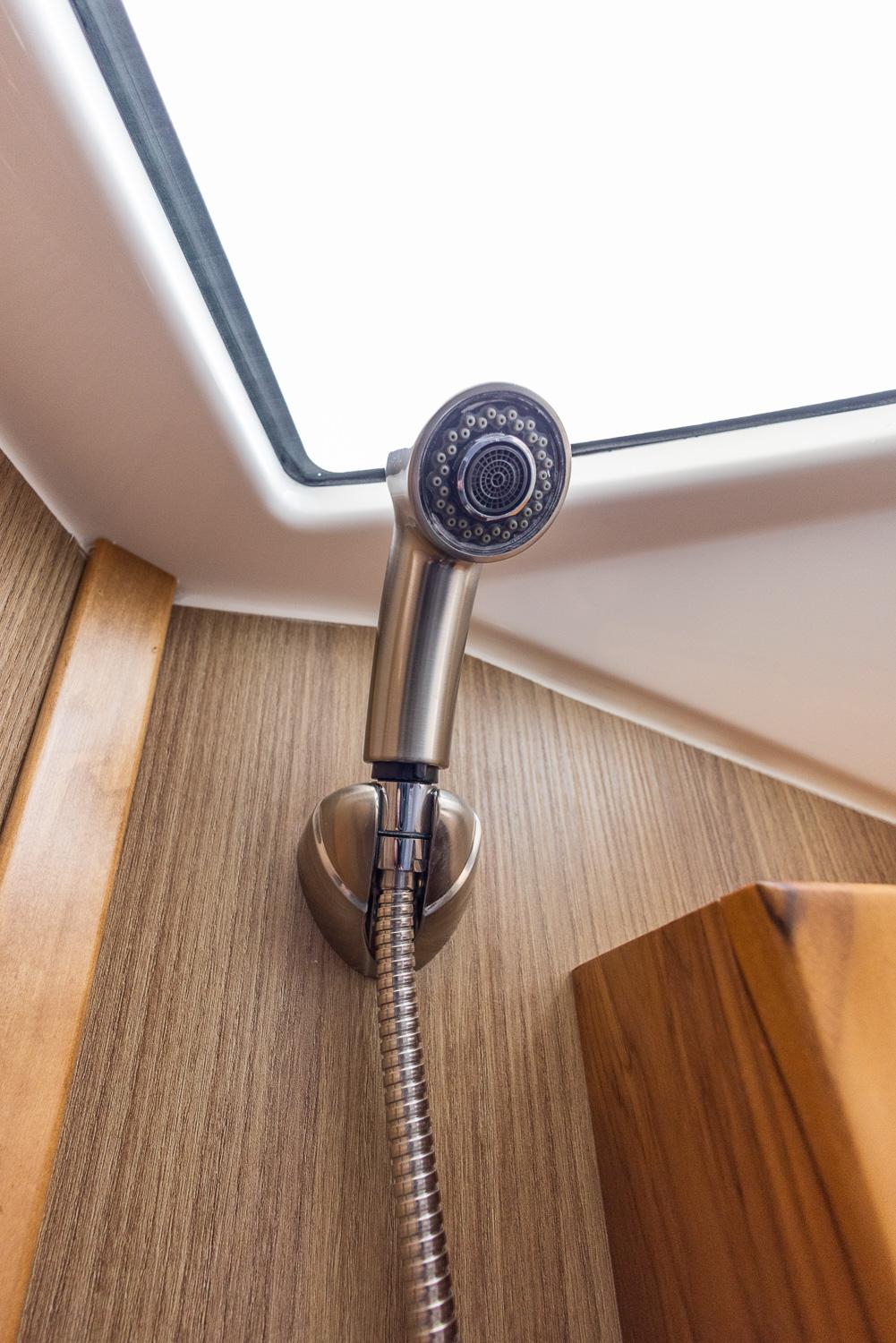Solara-S-310 CW 2025 -FL-US-Modern showerhead in Solara S-310 CW yacht, 2025 model, with wood paneling.-9624144 | Thumbnail