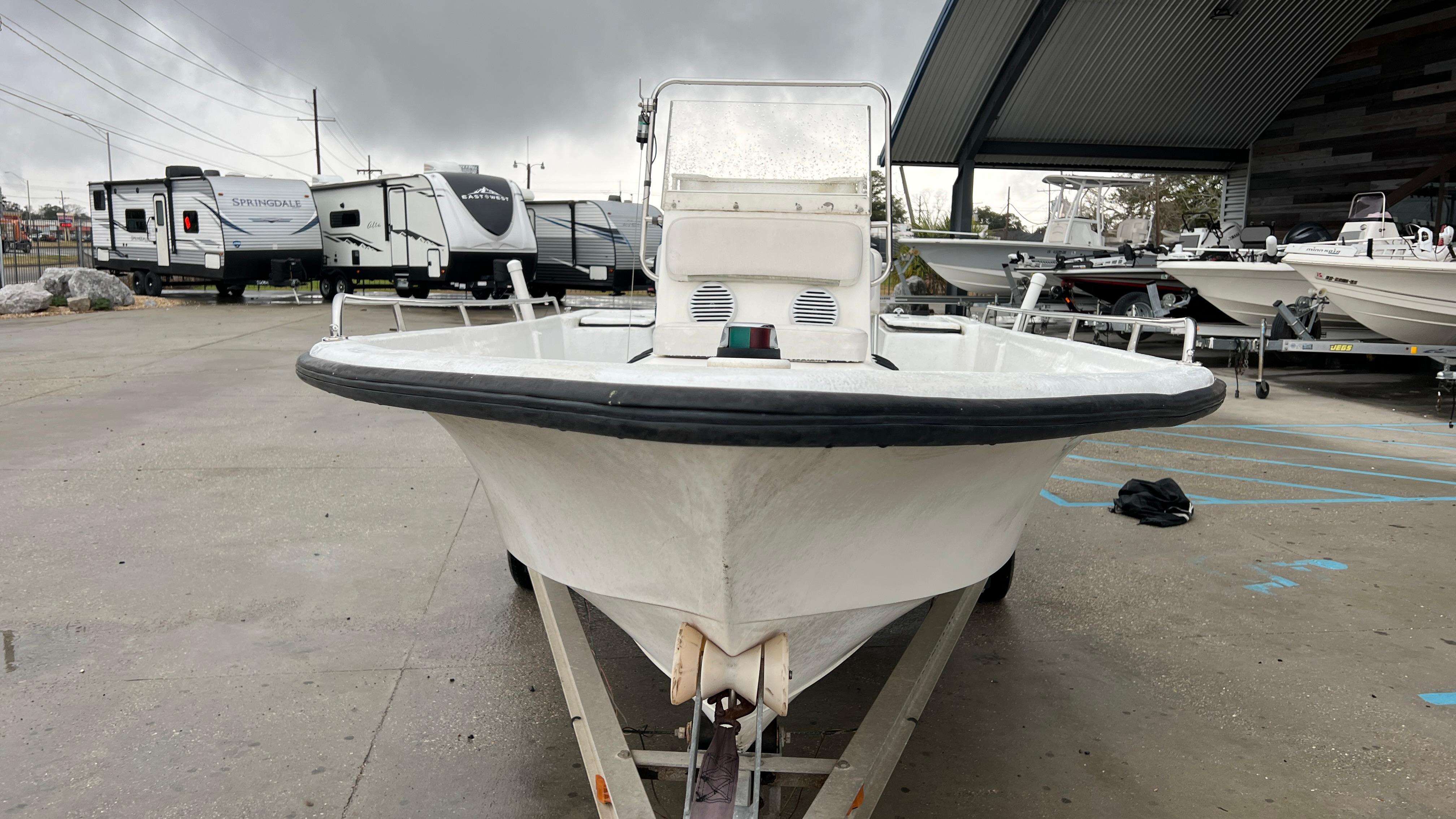 Front view of a 2000 Blazer 1860 boat on a trailer in a parking lot.