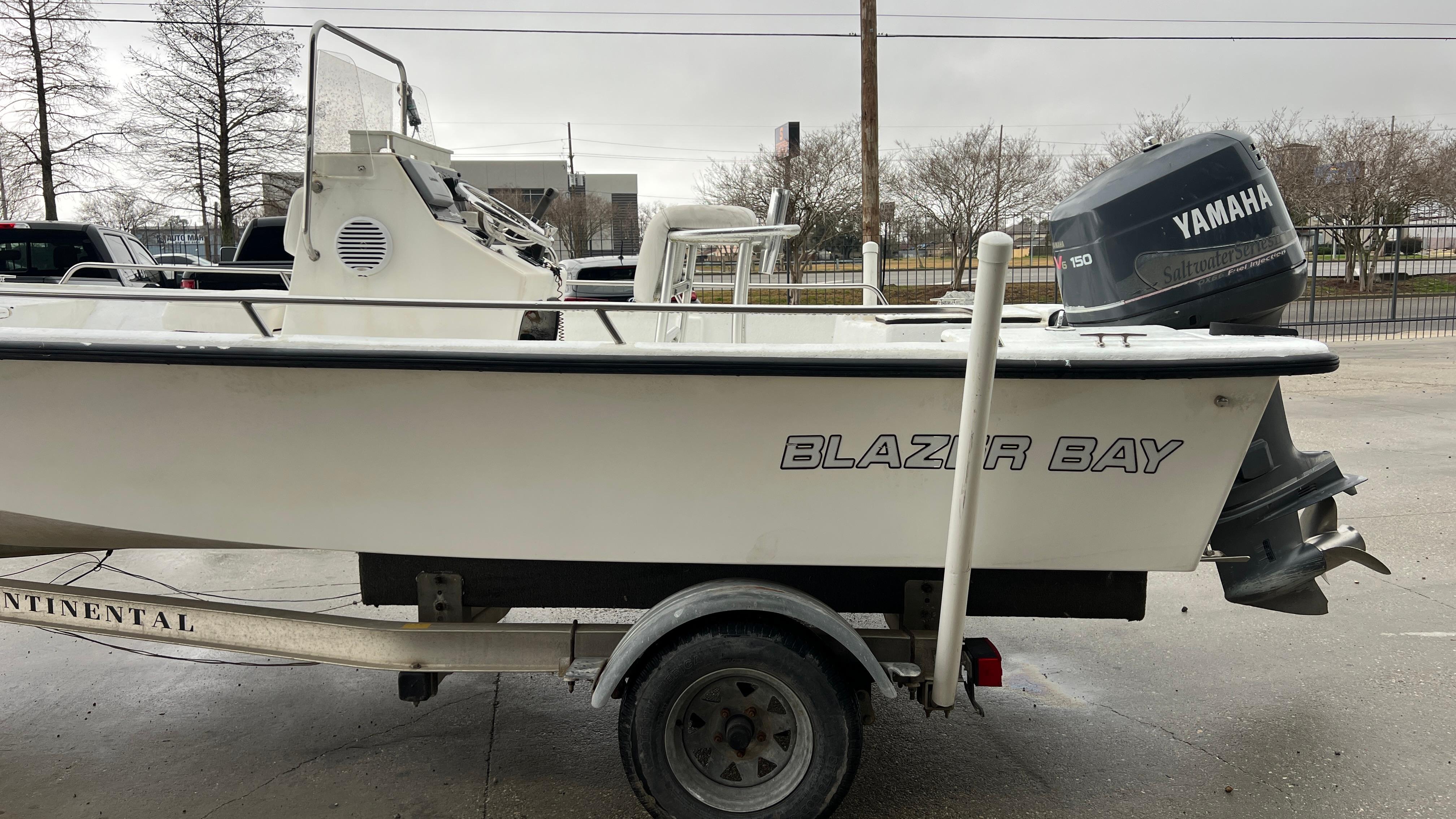 2000 Blazer 1860 boat on trailer with Yamaha outboard motor, parked outdoors.