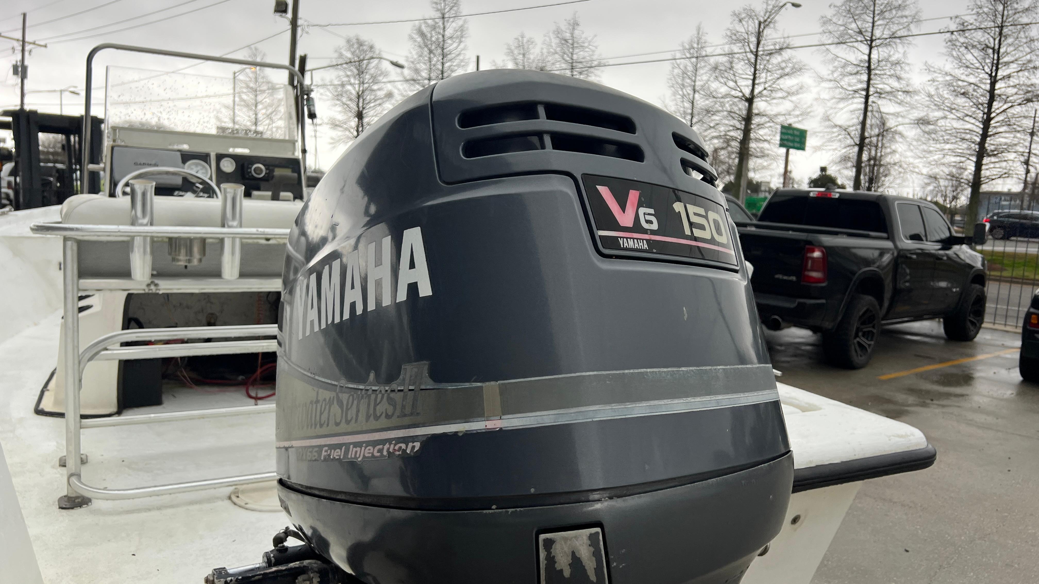 Boat with Yamaha V6 150 outboard motor, Blazer 1860 model, year 2000, in a parking lot.