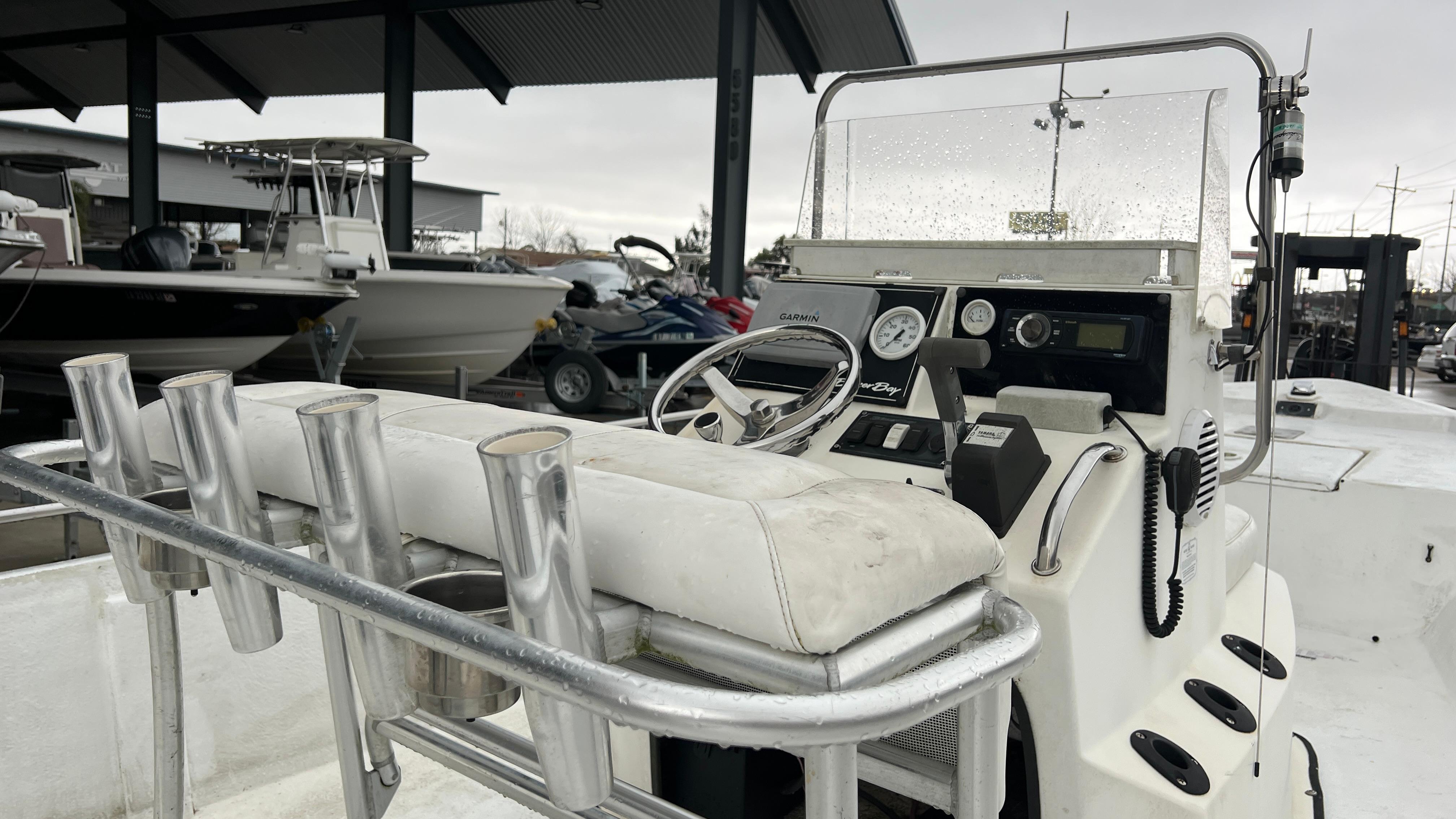 2000 Blazer 1860 boat console with steering wheel and rod holders in a marina setting.