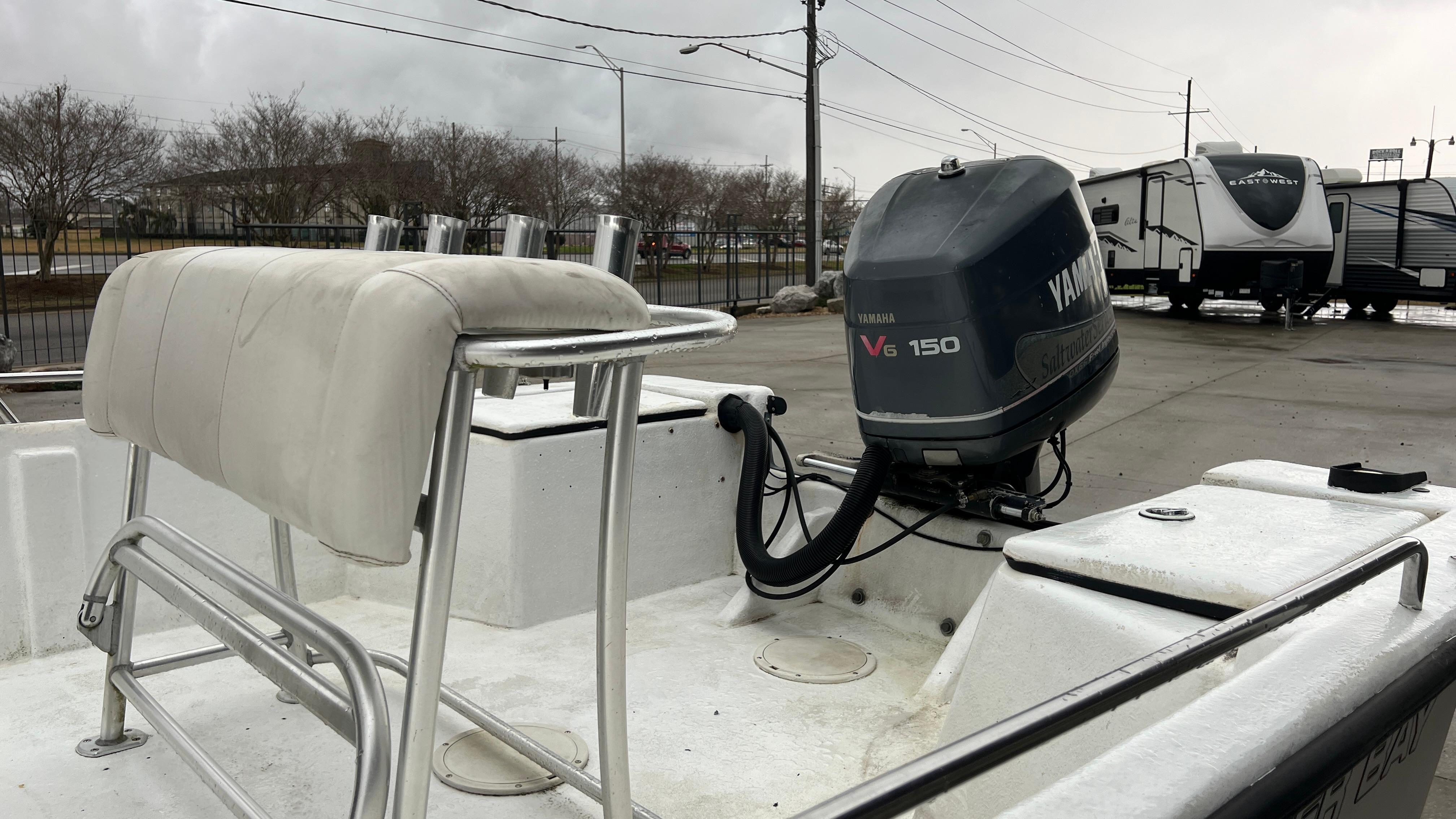 2000 Blazer 1860 boat with Yamaha V6 150 outboard motor in a parking lot.