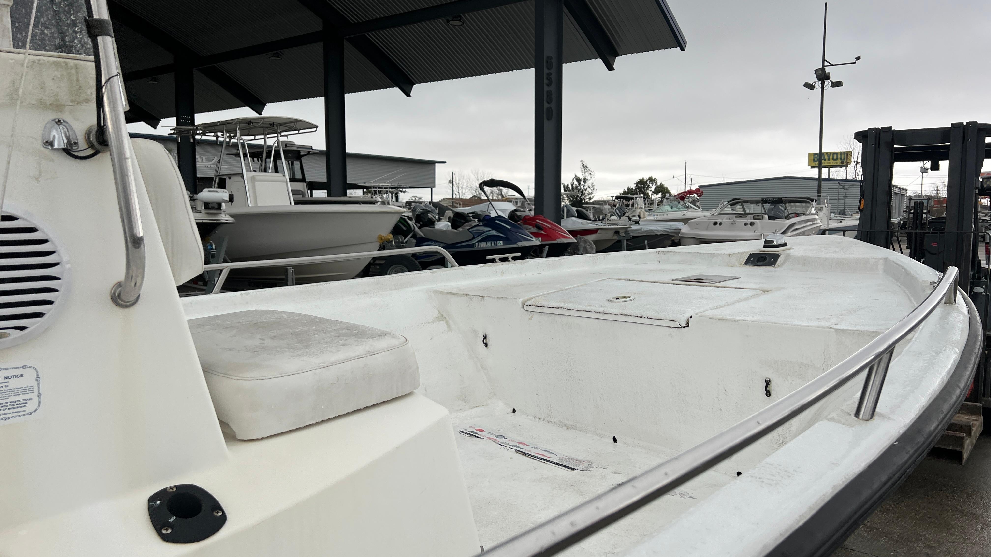 Boat docked in marina, Blazer 1860 model, year 2000, with overcast sky.