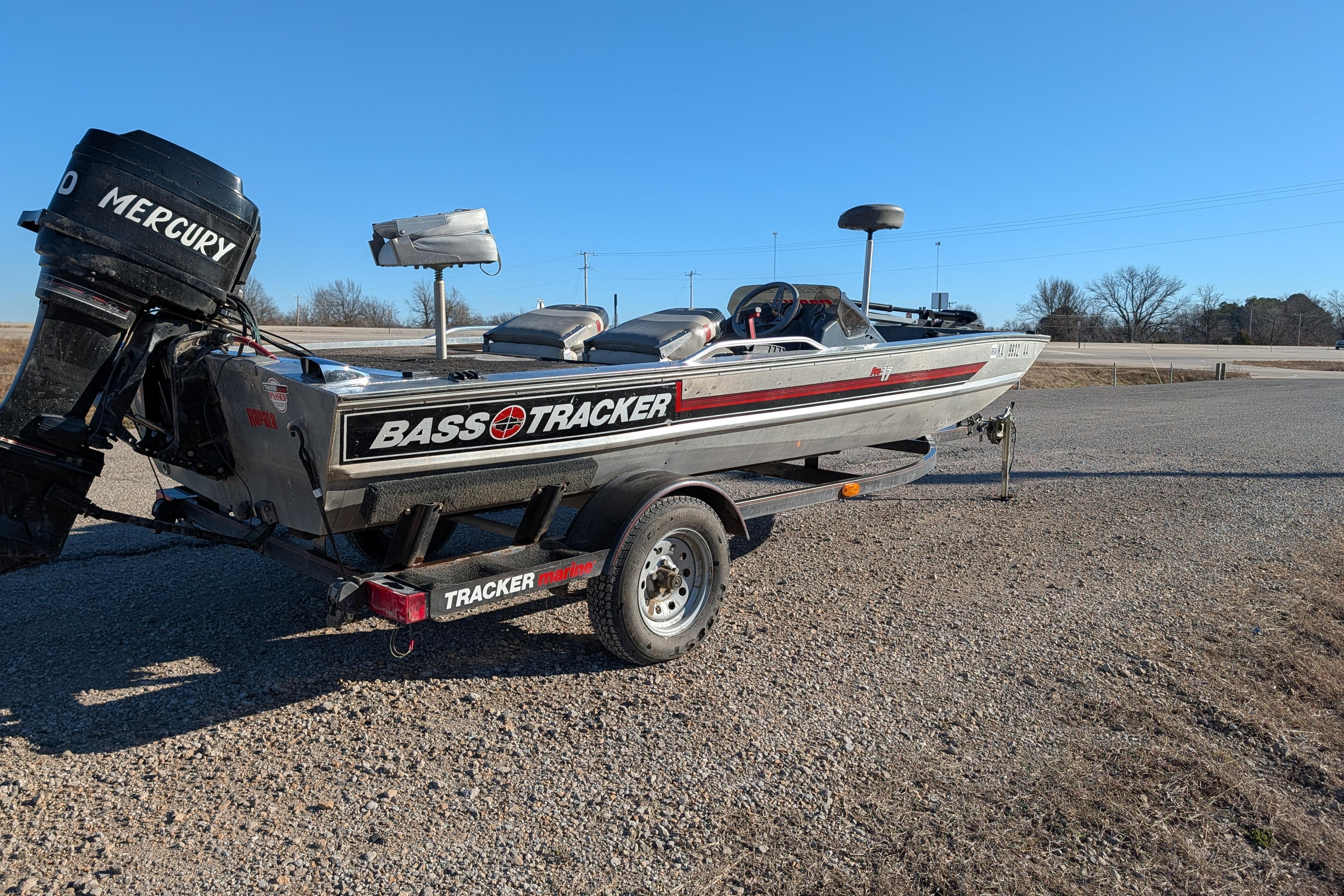 1988 Bass Tracker Pro 17 boat with Mercury engine on a trailer, parked outdoors.