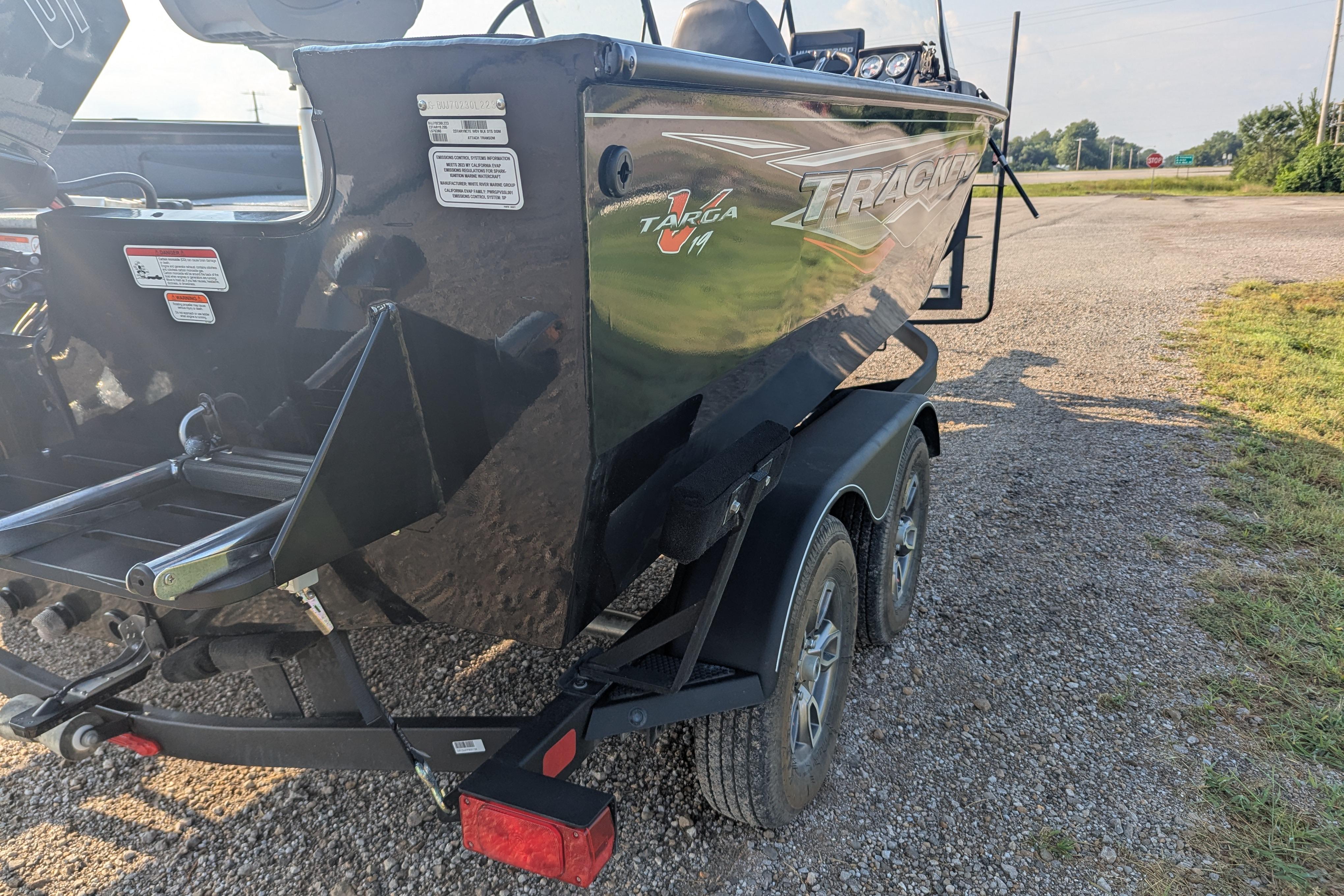 2023 Tracker Targa V-19 Combo Tournament Edition boat on a trailer, parked on gravel.