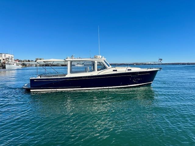 2014 MJM 36z Downeast boat on calm water under clear blue sky.
