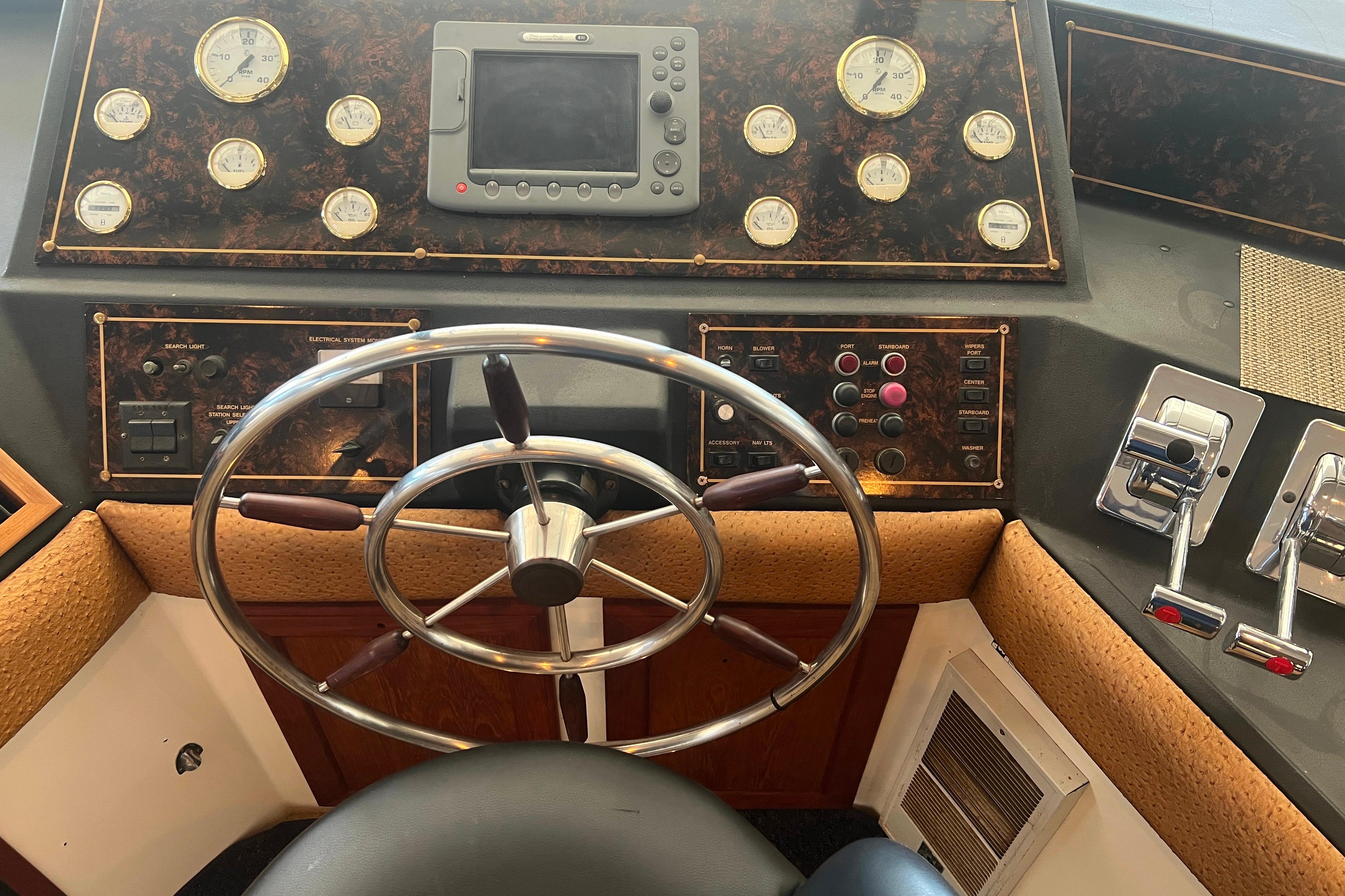 Pilothouse elm with gauges, steering wheel, and controls.