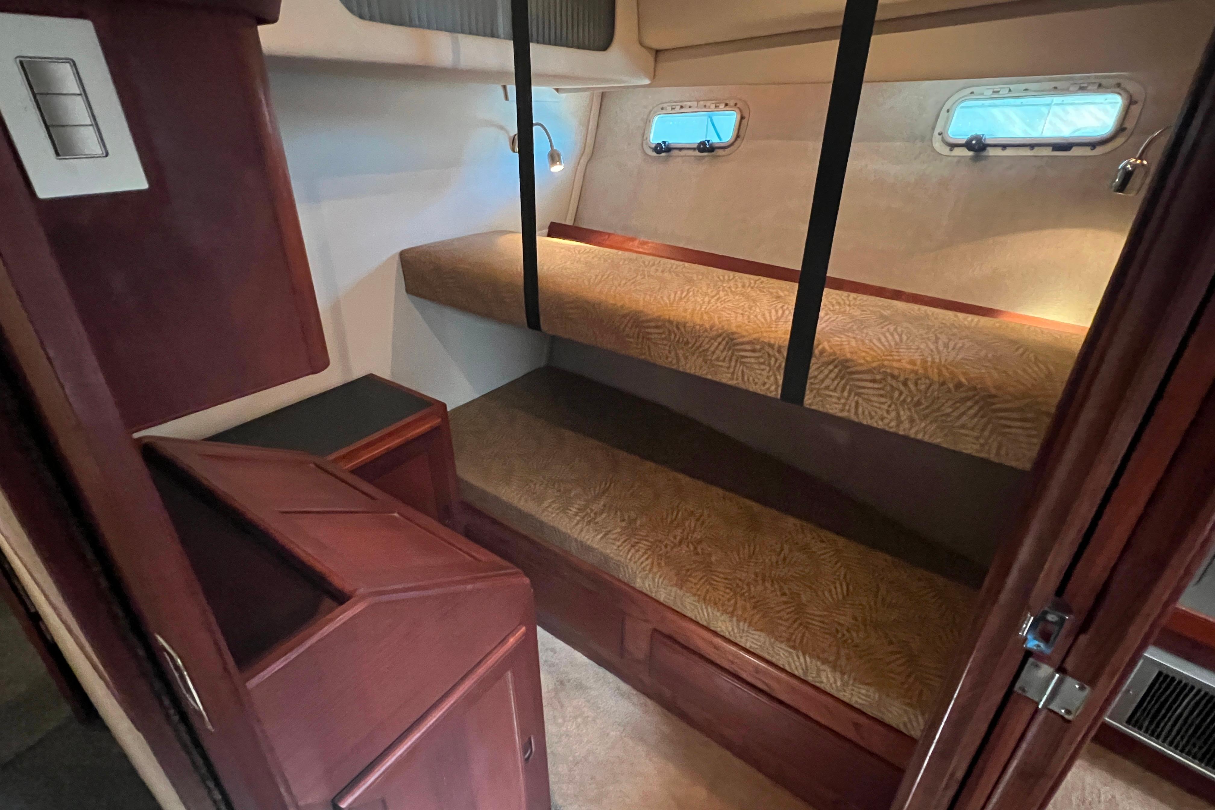 Interior cabin of 1986 Bayliner 4550 Motoryacht with bunk beds and porthole windows.
