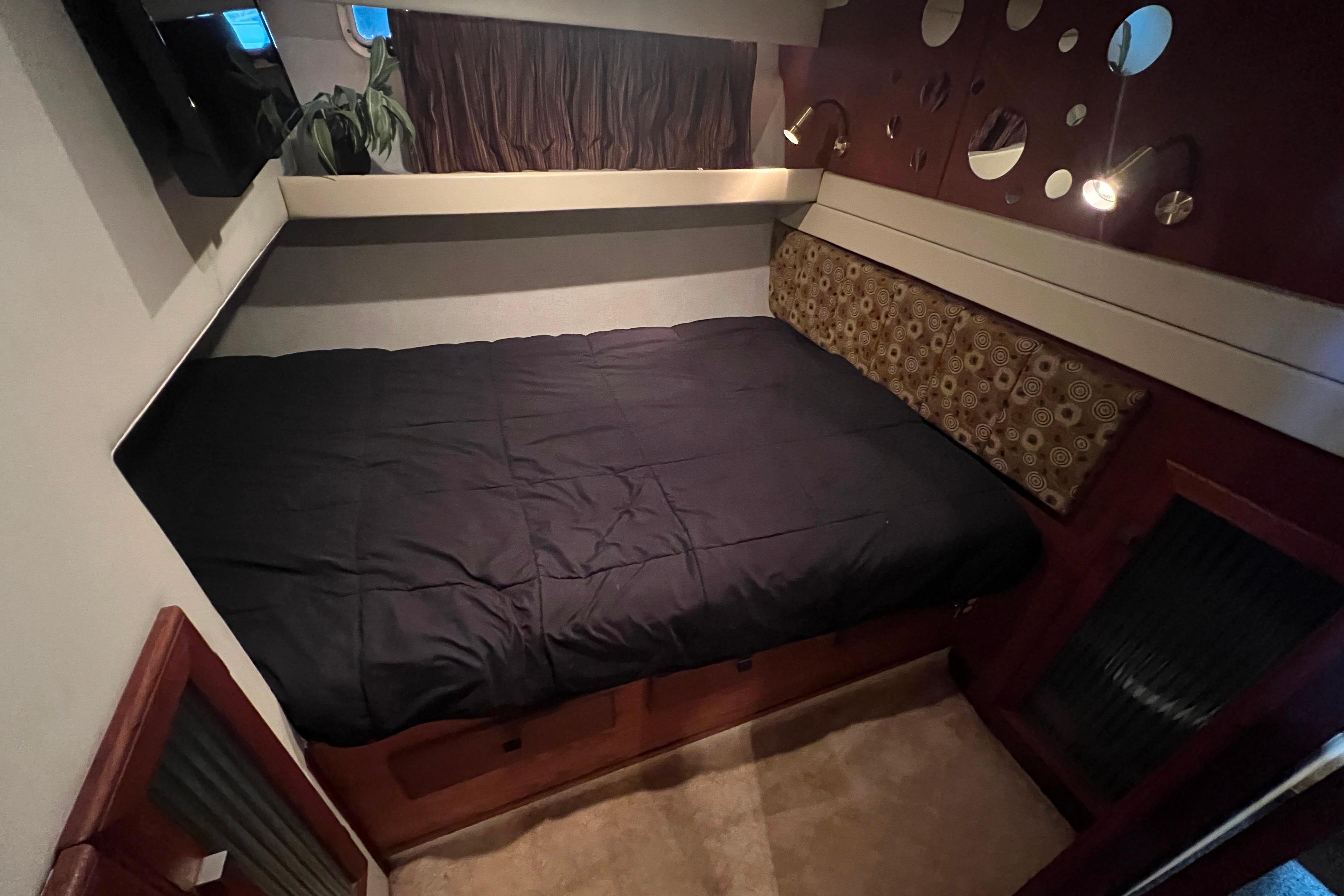 Cozy guest bedroom in 1986 Bayliner 4550 Motoryacht with modern decor and comfortable bedding.