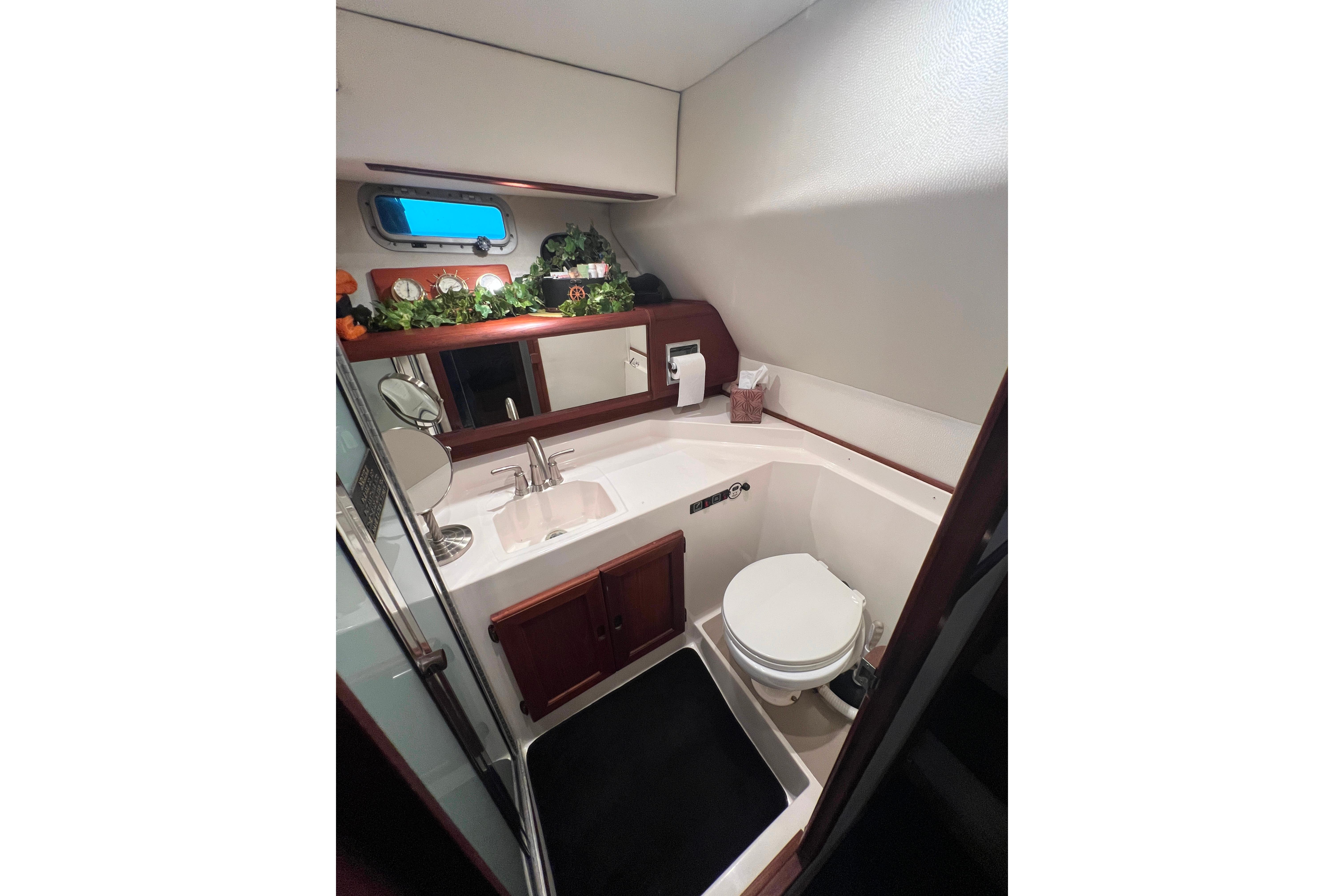 Luxurious guest bathroom in 1986 Bayliner 4550 Motoryacht with sink, toilet, and mirror.