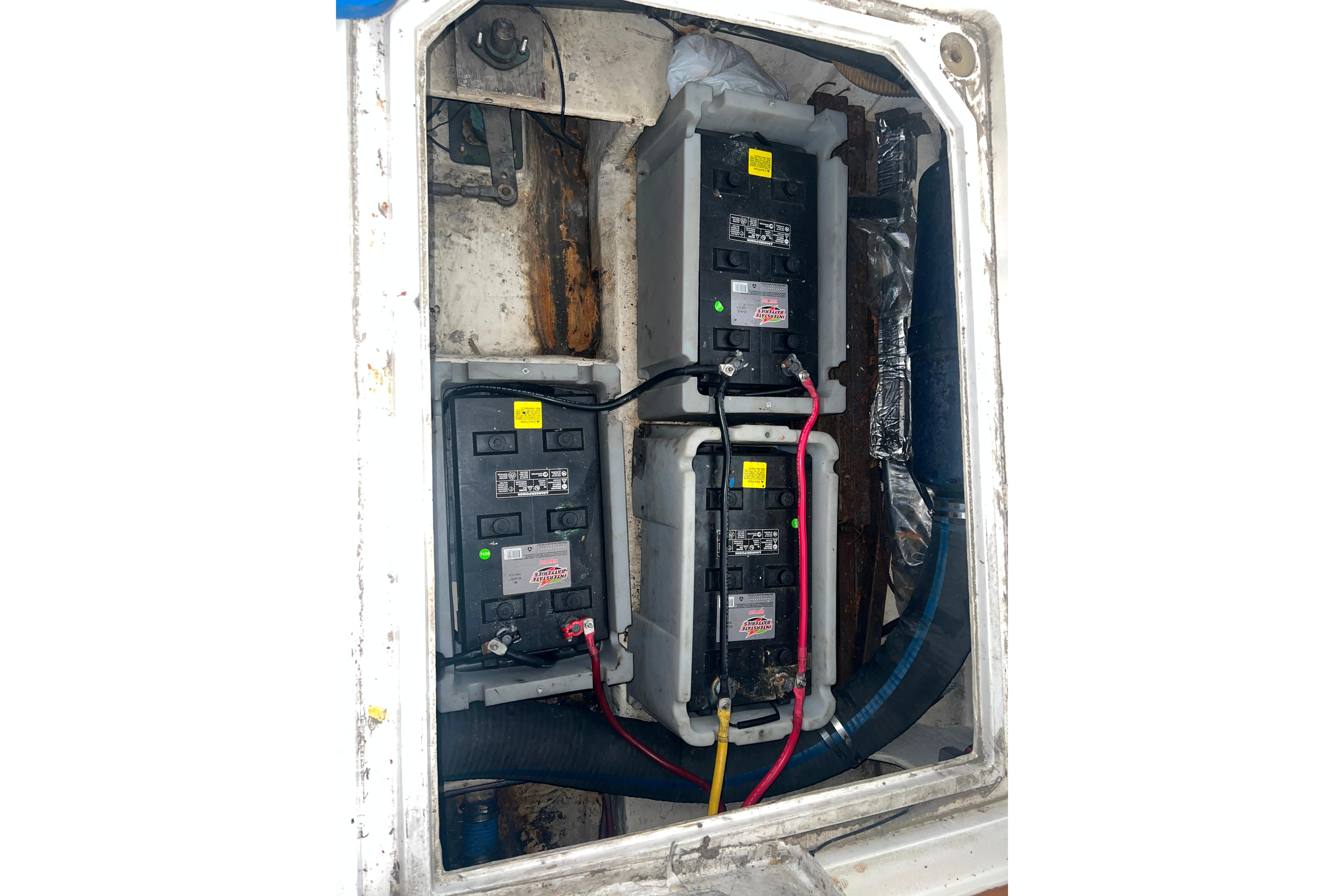 Battery compartment of 1986 Bayliner 4550 Motoryacht with wiring and connections visible.