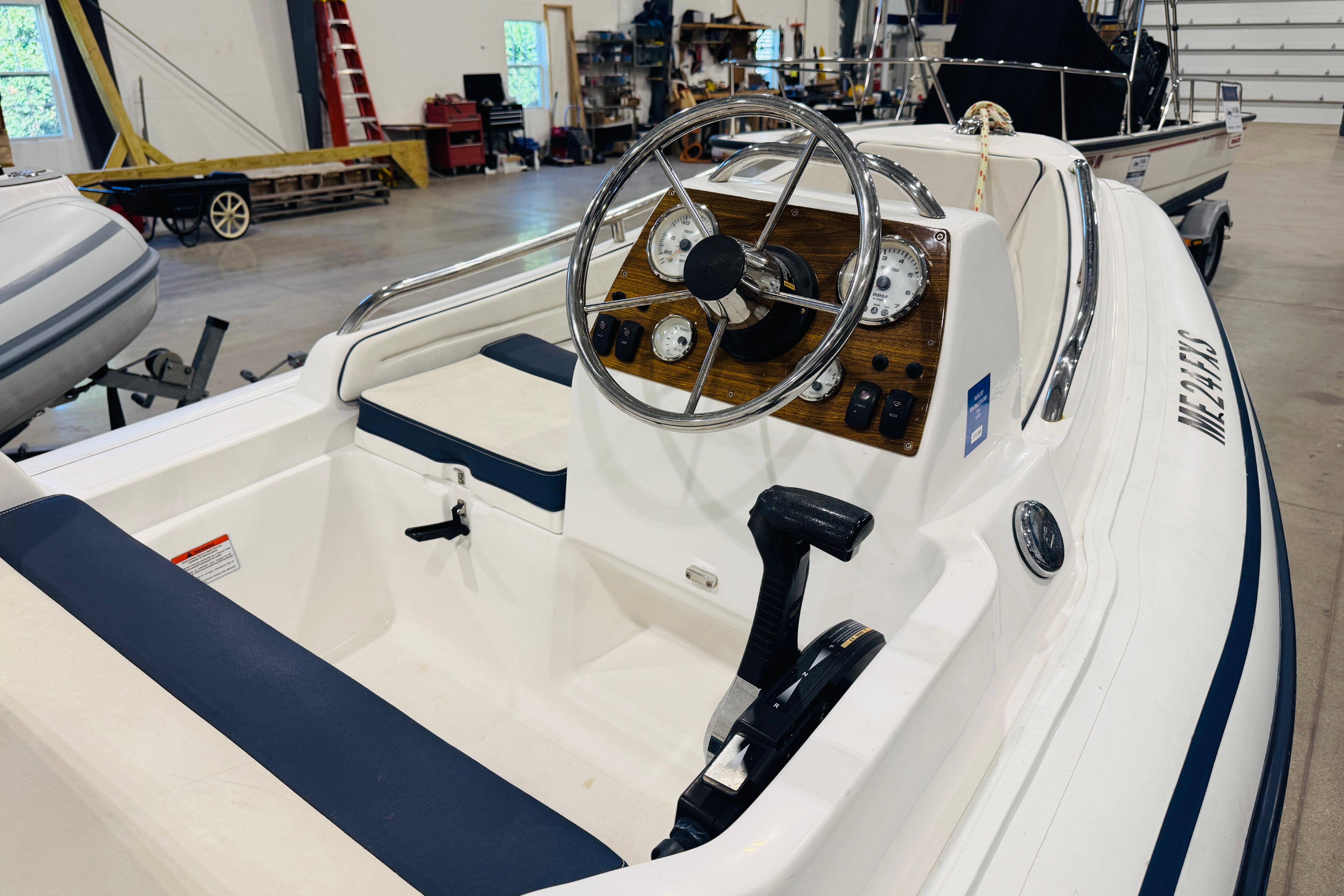 2019 AB Inflatables Nautilus 11 DLX boat interior with steering wheel and controls in a garage.