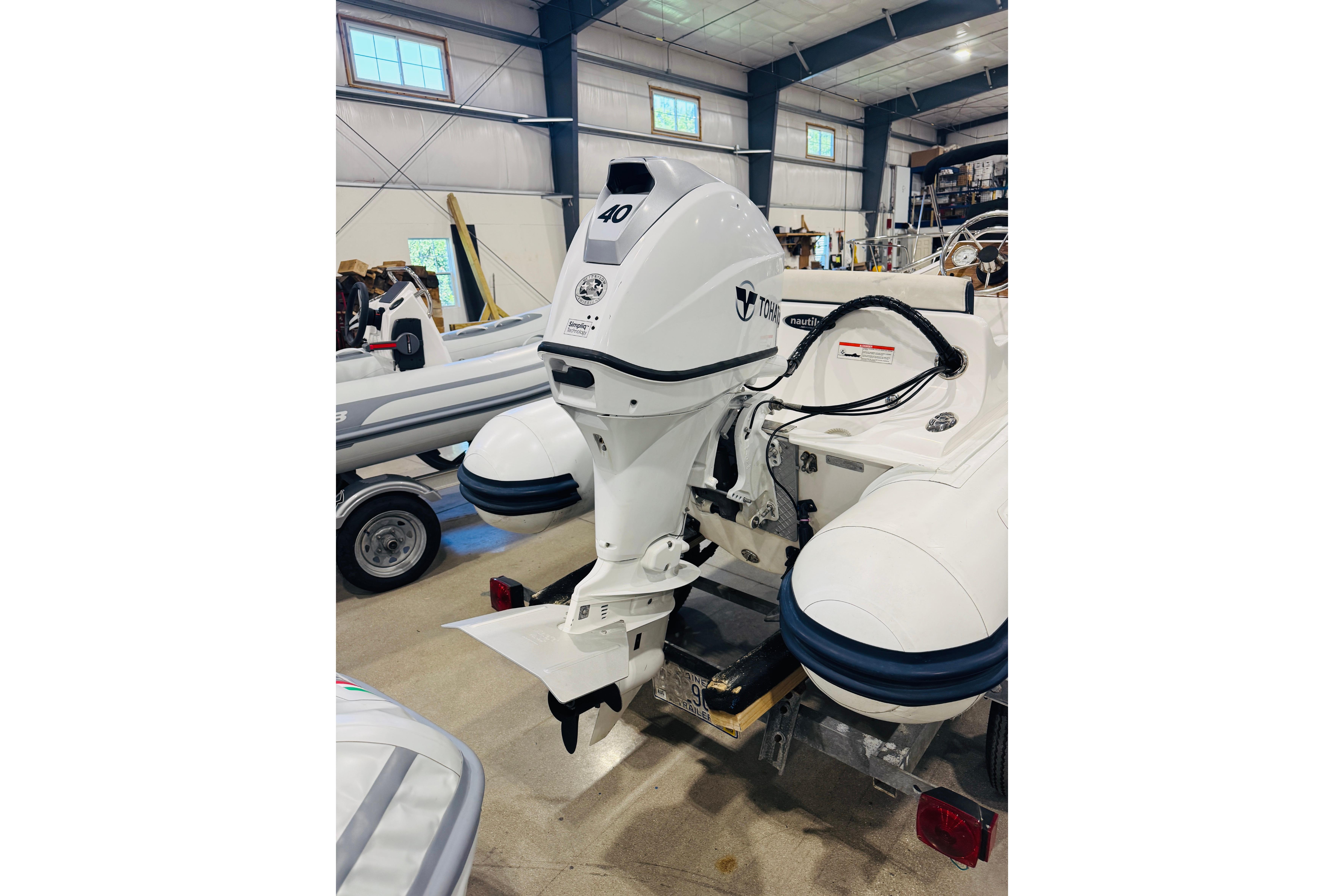 2019 AB Inflatables Nautilus 11 DLX with outboard motor in a showroom.