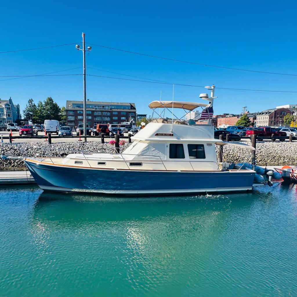 2006 Sabre 42 Fly Bridge yacht docked in a marina under clear blue skies.