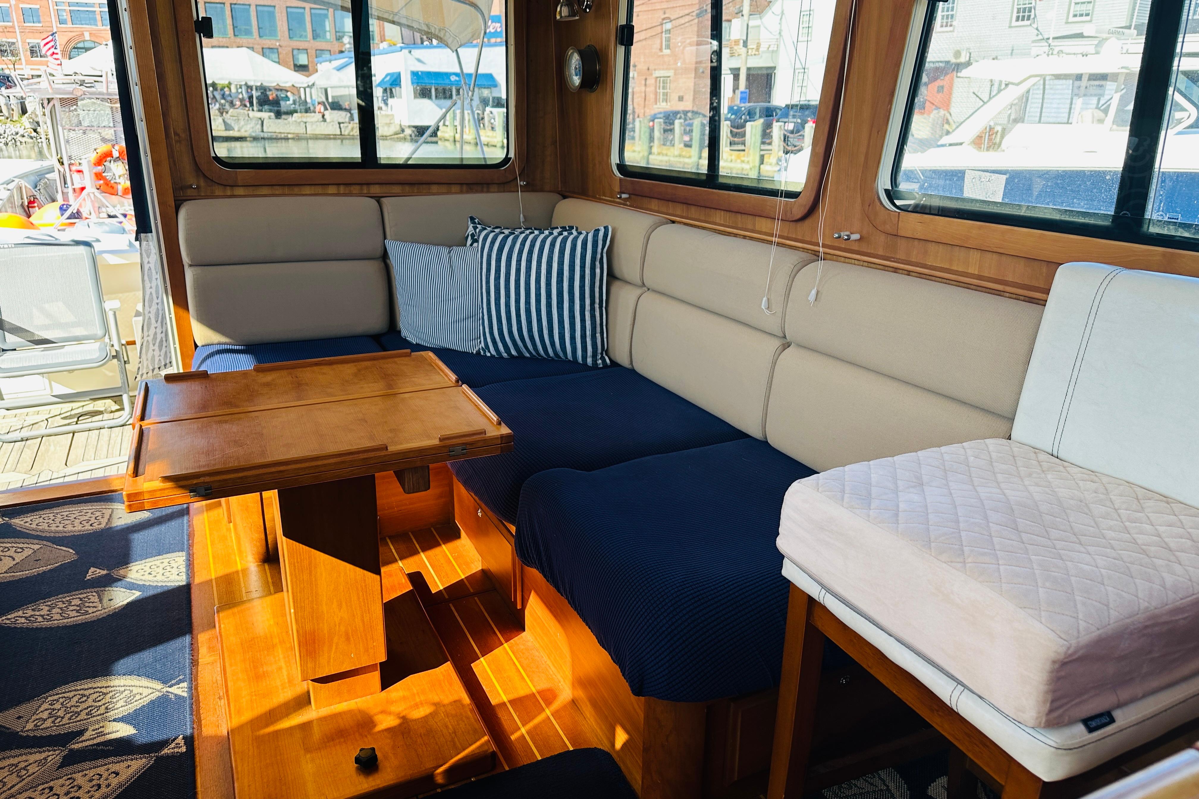 Interior of 2006 Sabre 42 Fly Bridge with cozy seating and wooden table.