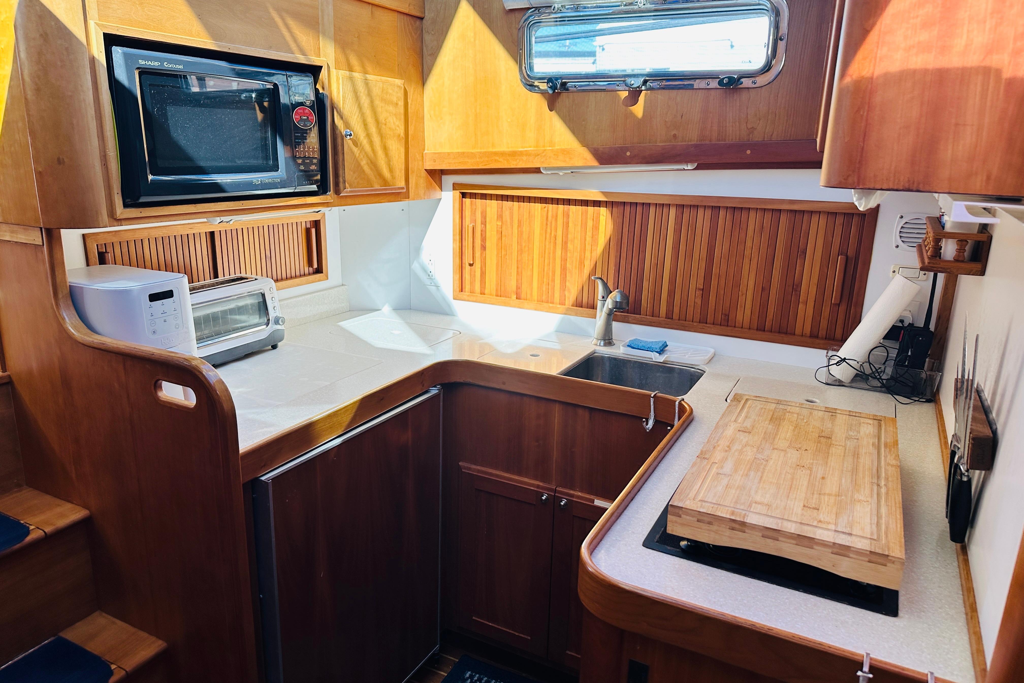 Cozy kitchen in 2006 Sabre 42 Fly Bridge yacht with wooden cabinetry and modern appliances.