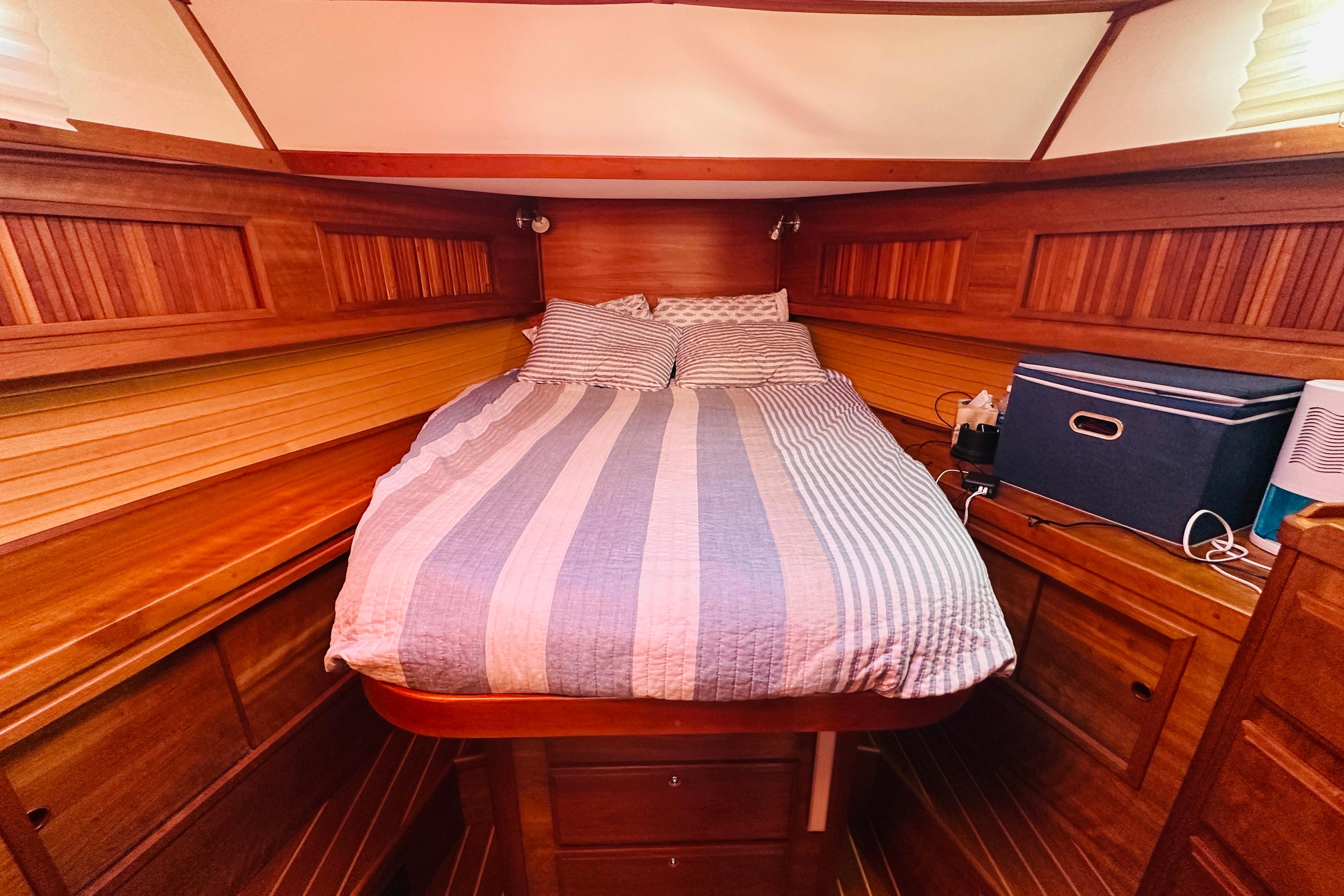 Cozy cabin interior of 2006 Sabre 42 Fly Bridge with wooden finish and striped bedding.
