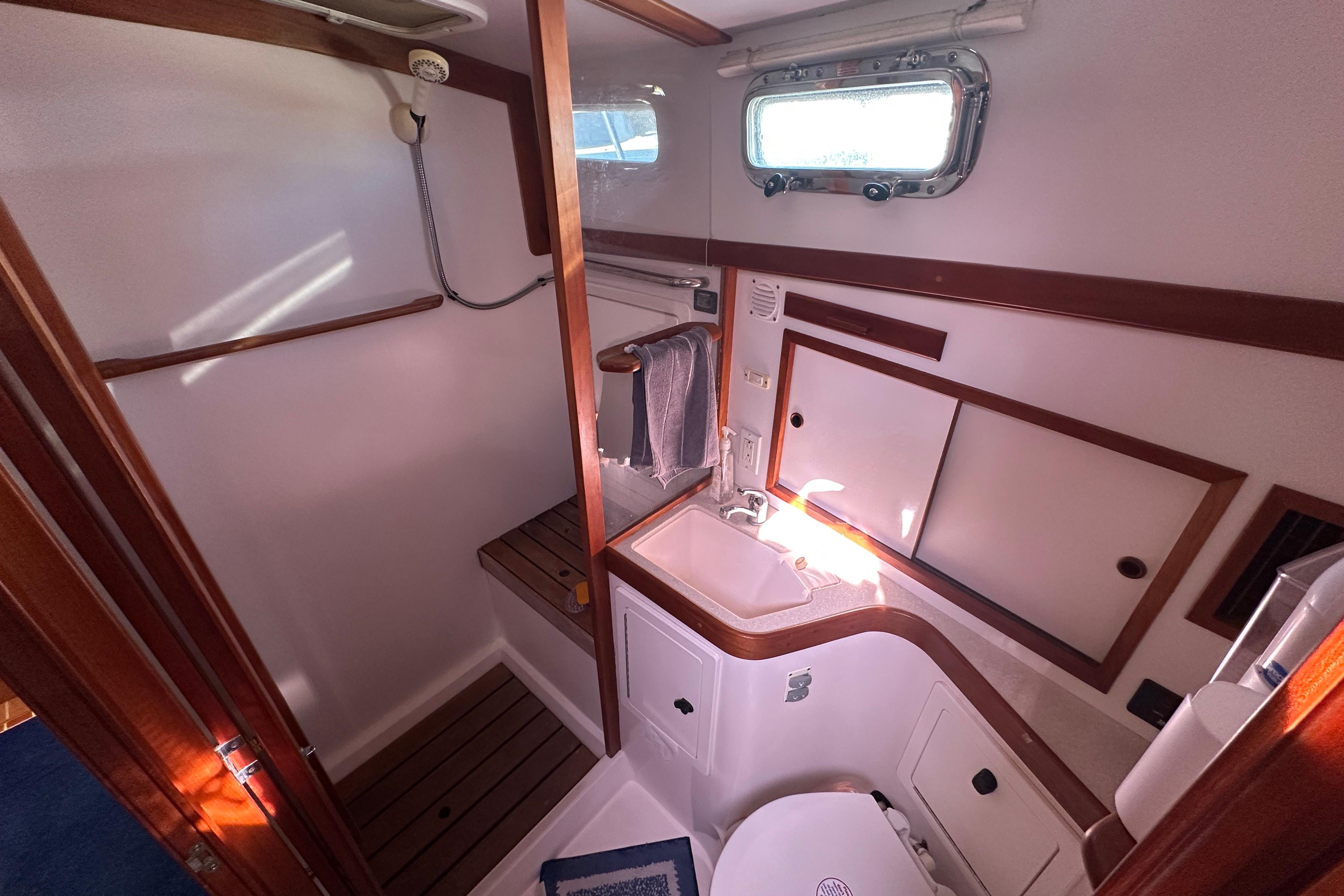 2006 Sabre 42 Fly Bridge bathroom with shower, sink, and wooden accents.