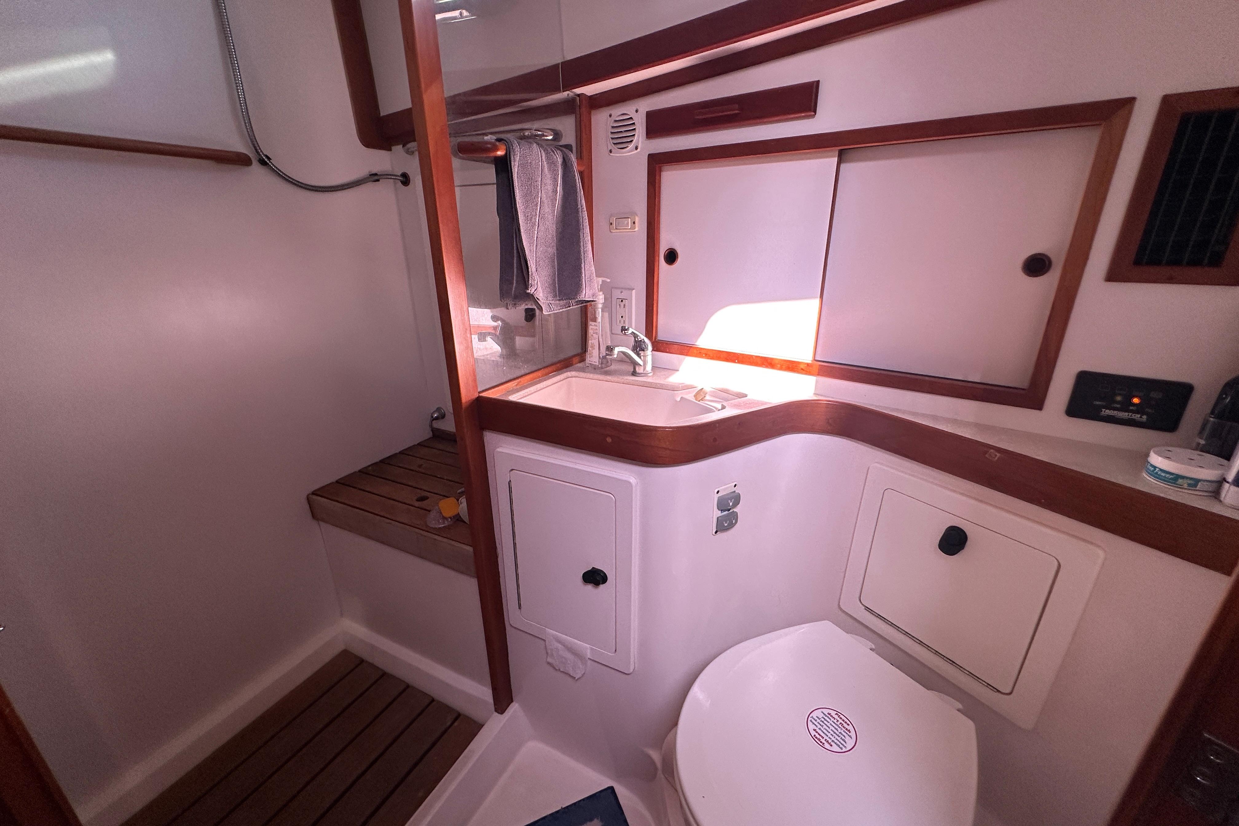 2006 Sabre 42 Fly Bridge yacht bathroom with sink, toilet, and wooden accents.