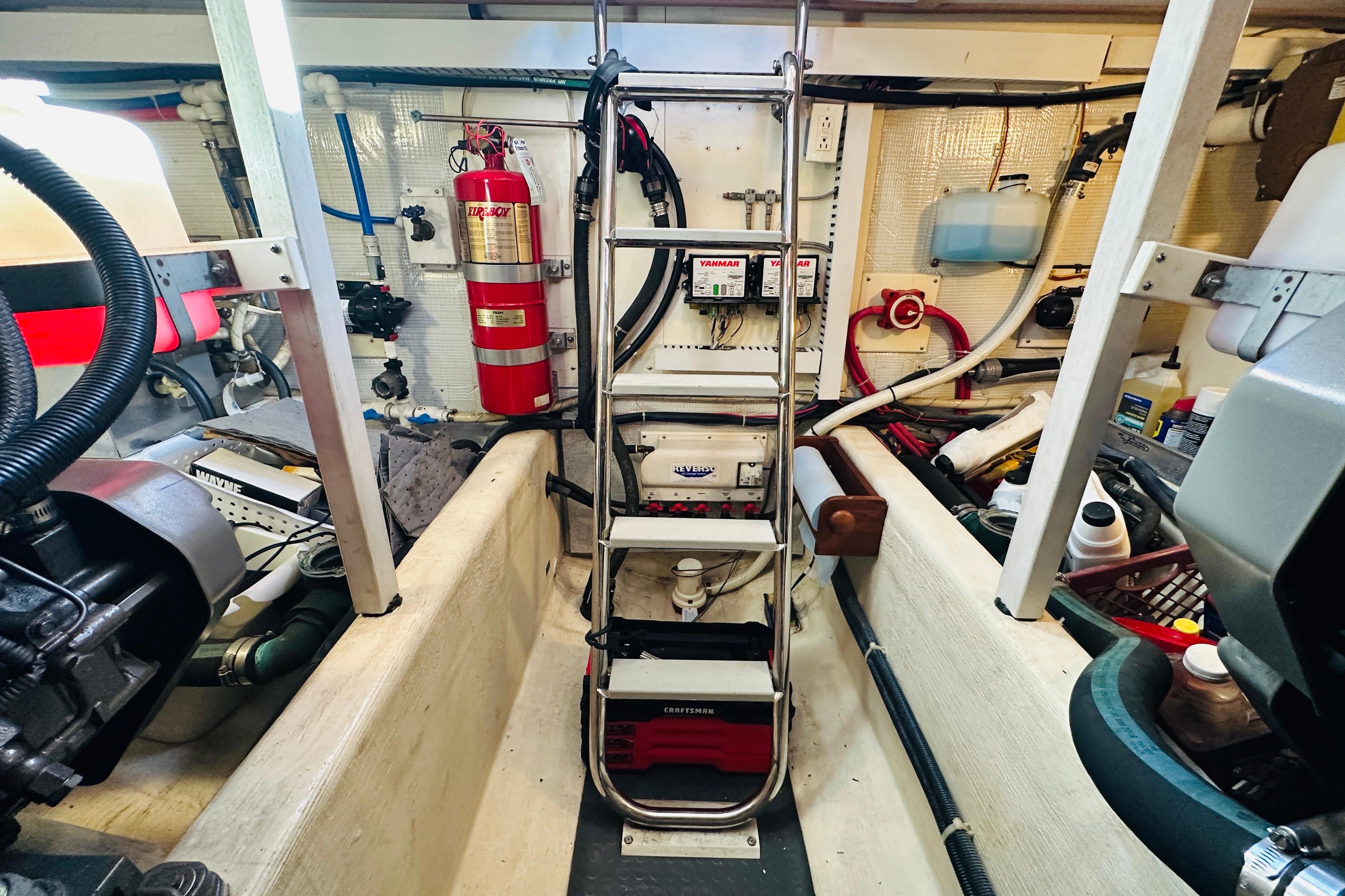 Engine room of 2006 Sabre 42 Fly Bridge with equipment and fire extinguisher.