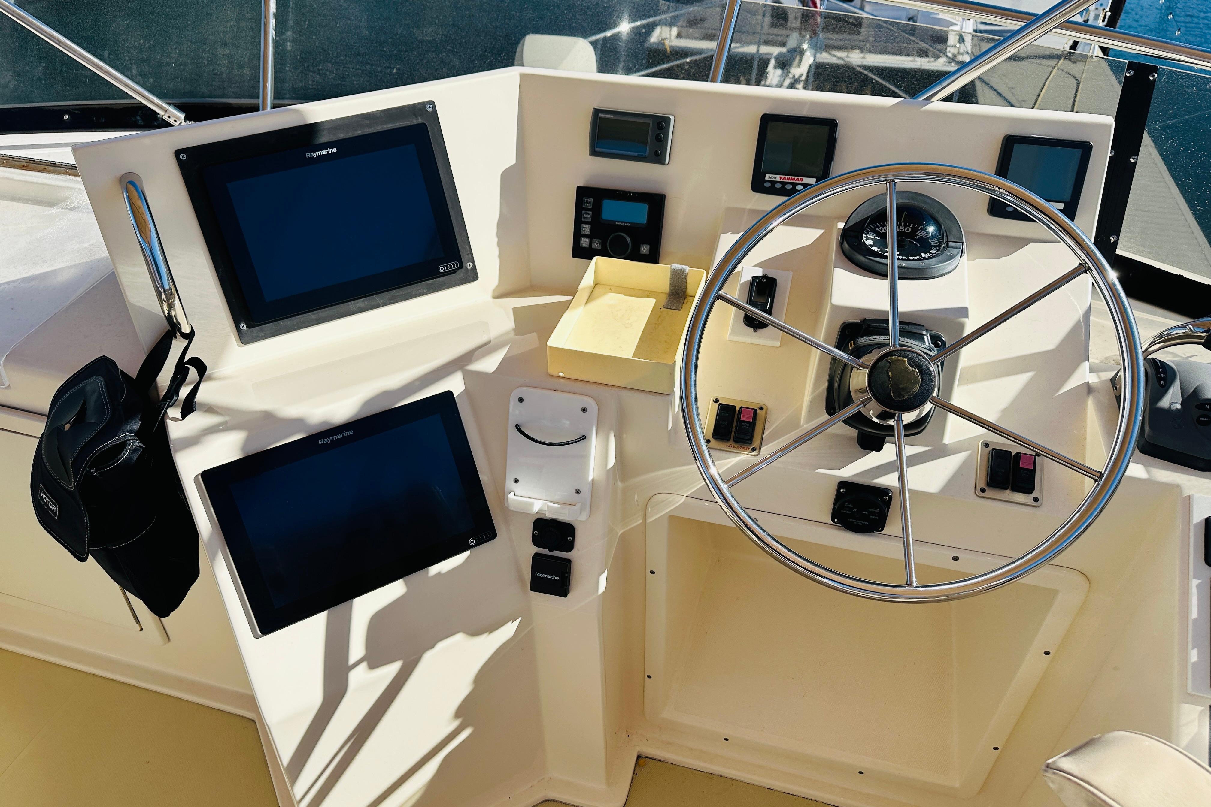 Helm of 2006 Sabre 42 Fly Bridge with navigation screens and steering wheel.