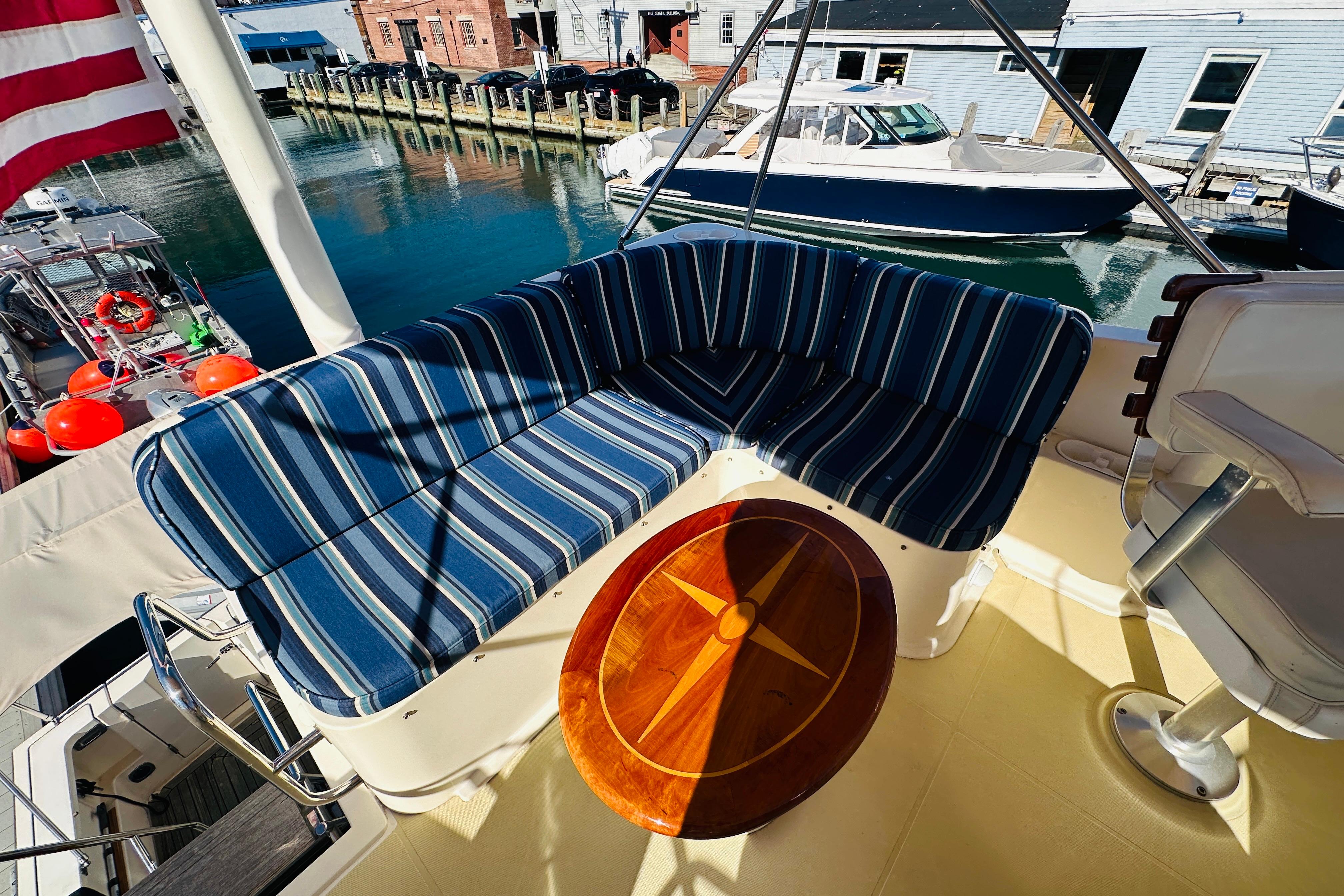 2006 Sabre 42 Fly Bridge with striped seating and wooden table, docked at marina.