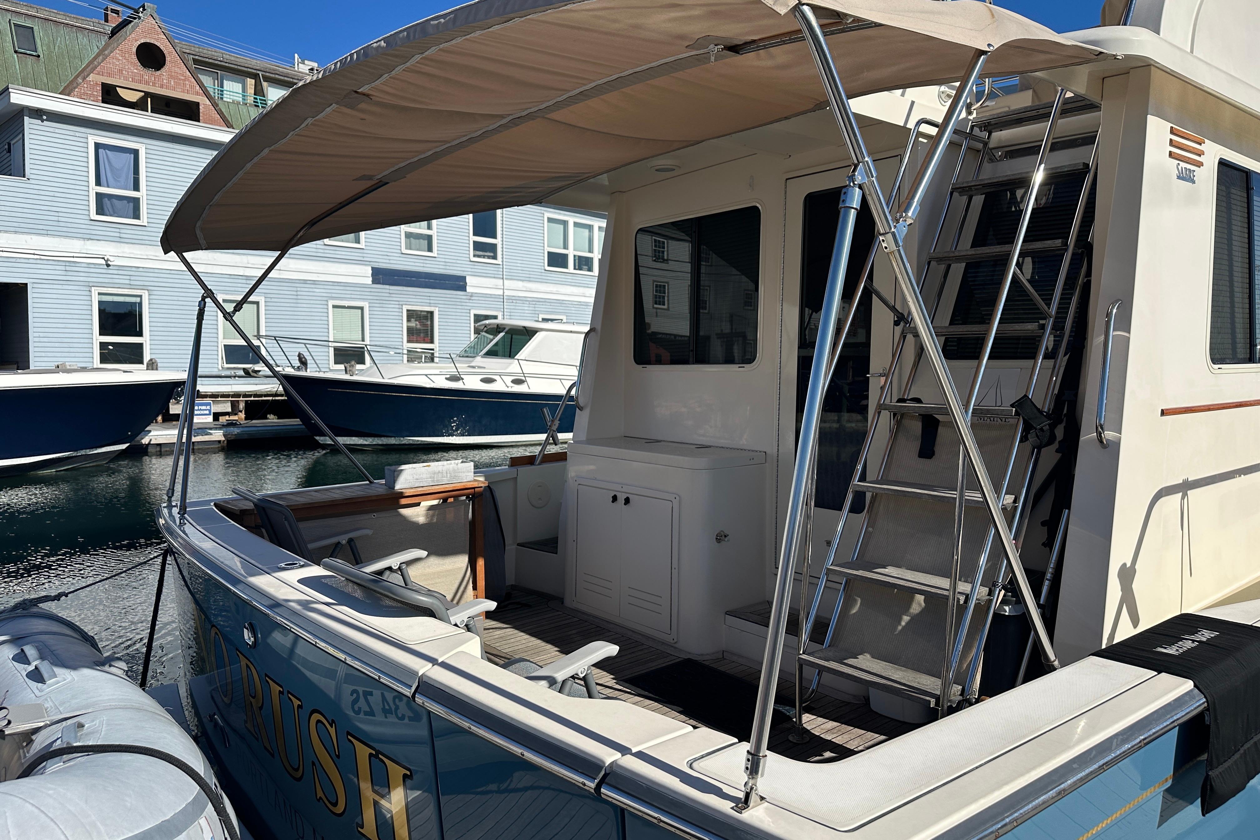 2006 Sabre 42 Fly Bridge yacht docked, featuring a shaded deck and ladder access.