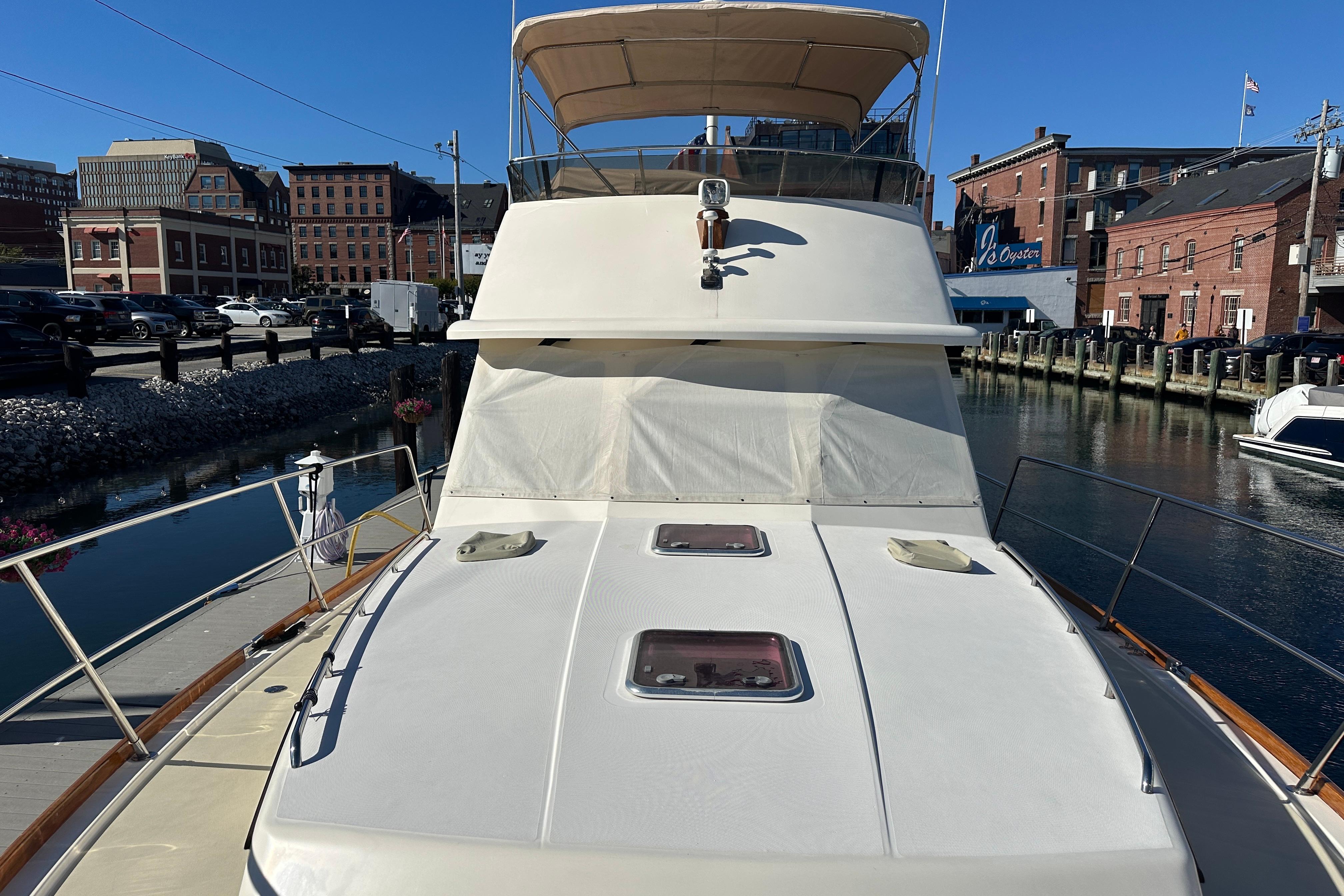 2006 Sabre 42 Fly Bridge yacht docked in urban marina setting.
