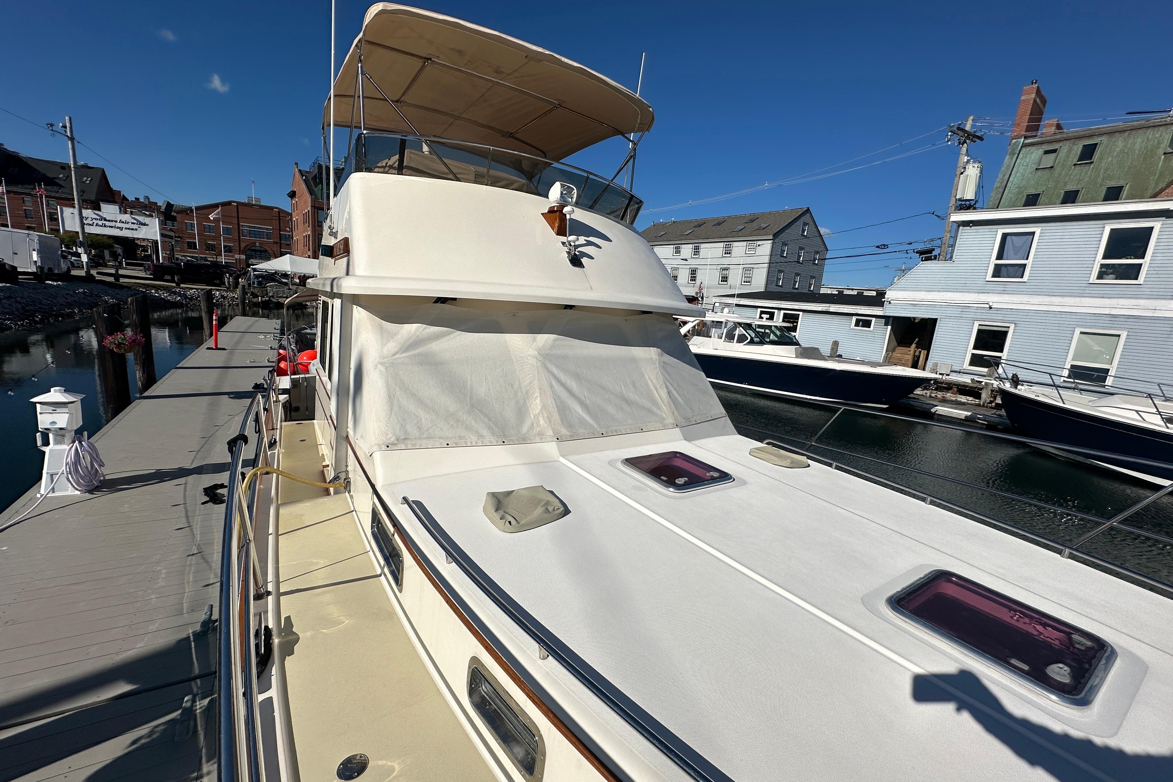 2006 Sabre 42 Fly Bridge yacht docked at marina under clear blue sky.