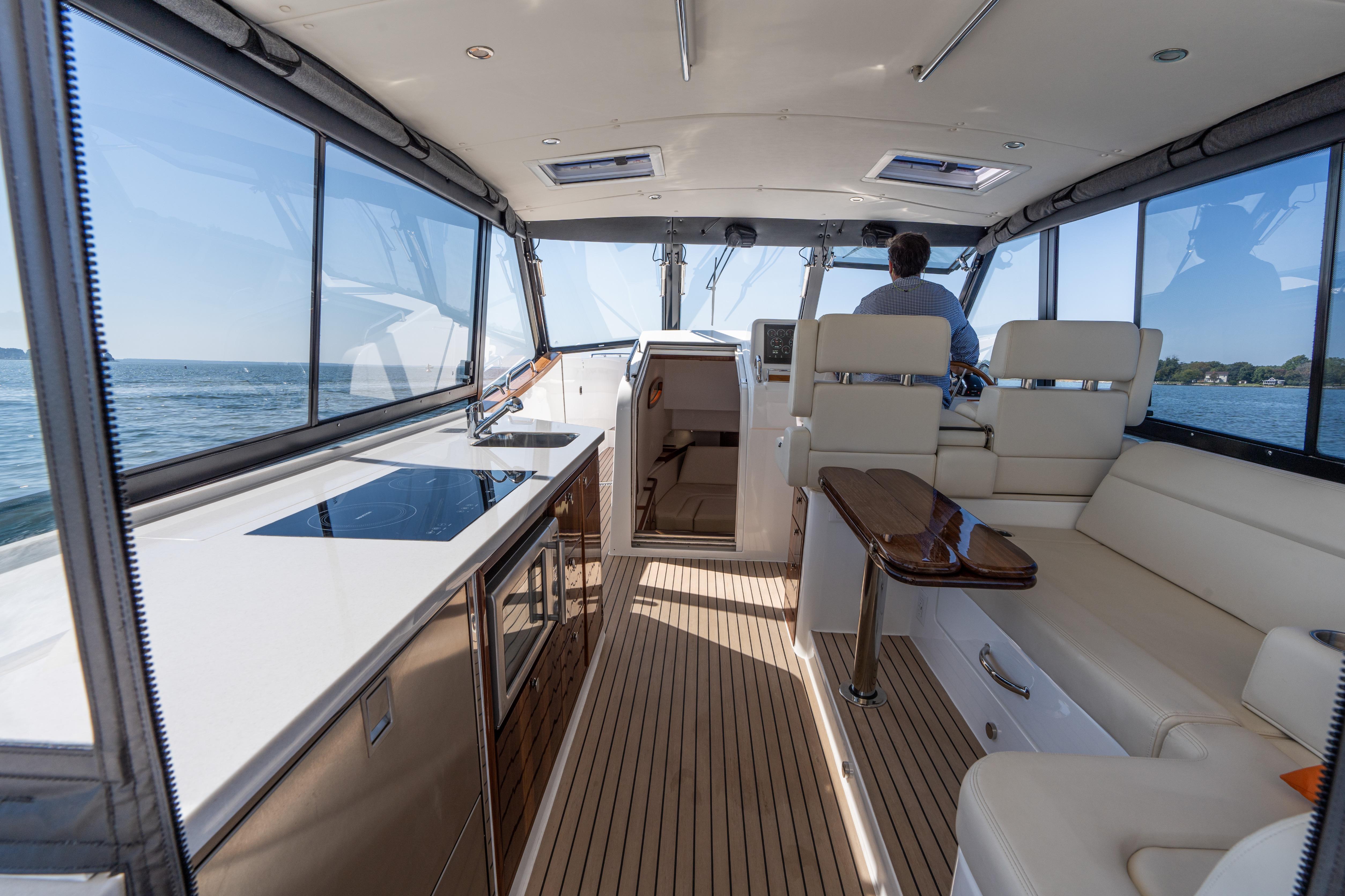 2023 MJM Yachts 4 interior with modern seating, kitchenette, and panoramic windows.