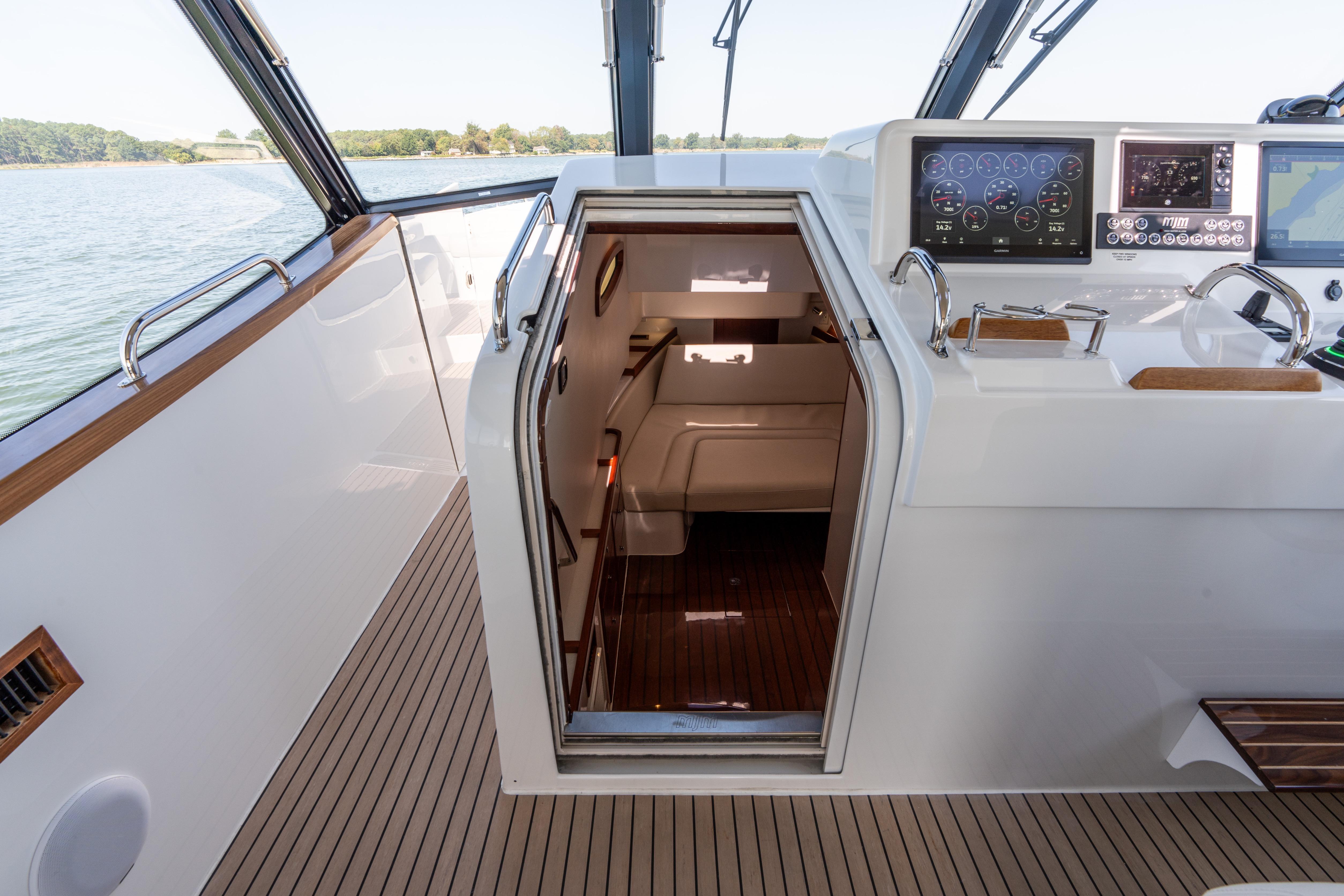 2023 MJM Yachts 4 interior with helm, navigation screens, and cabin entrance.