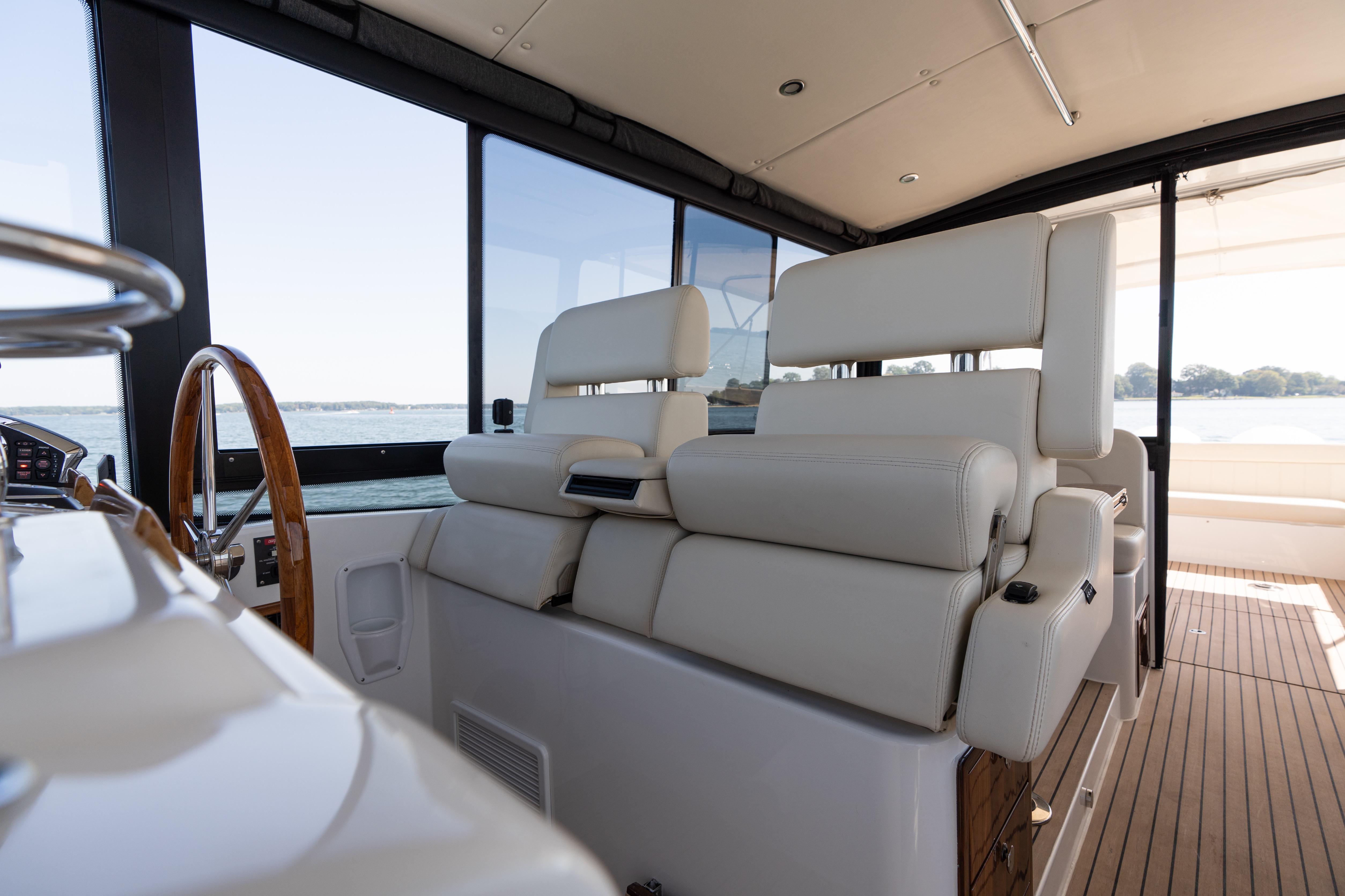Interior of 2023 MJM Yachts 4, featuring luxurious seating and wooden steering wheel.