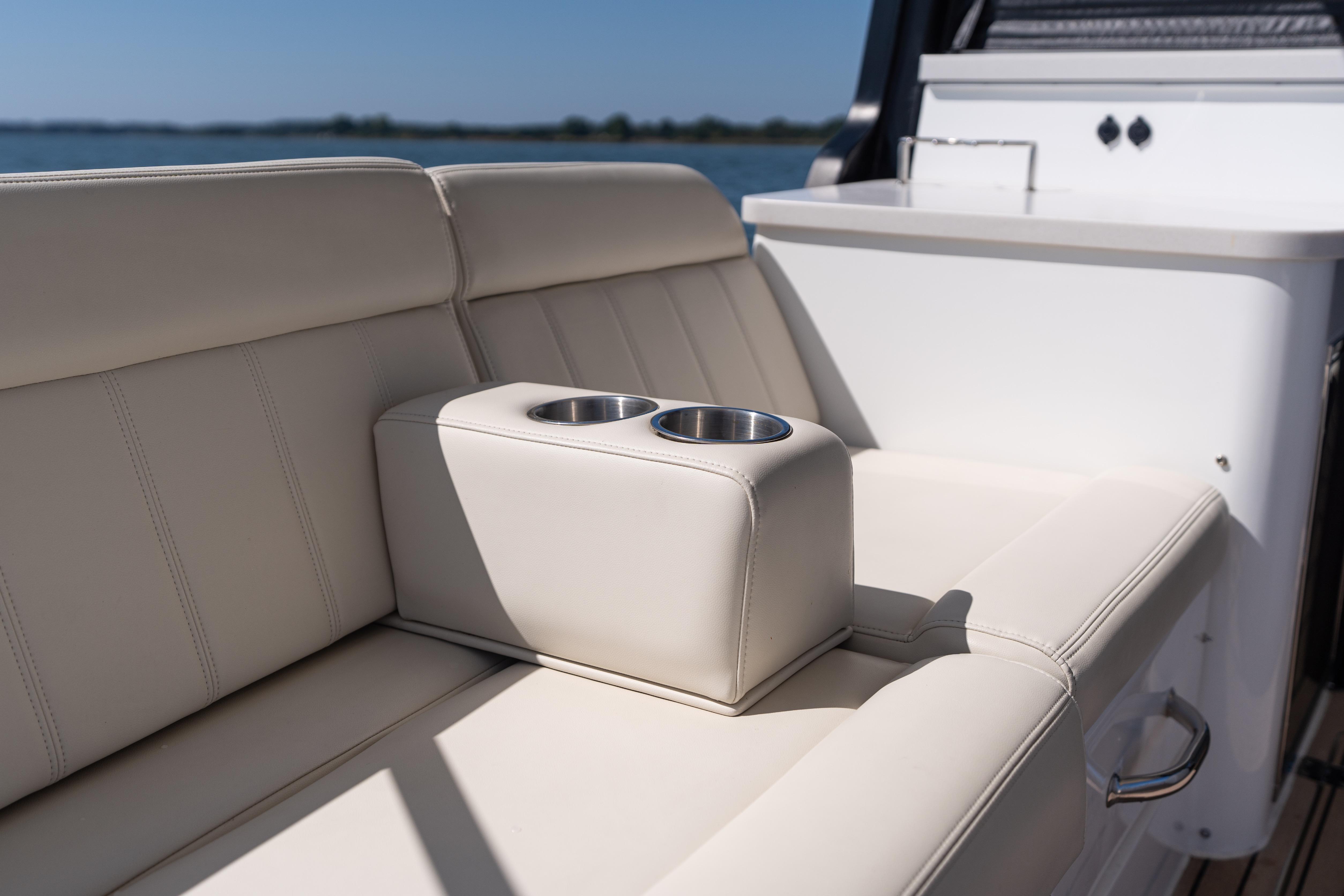 Luxurious seating on 2023 MJM Yachts 4 with built-in cup holders, ocean view.