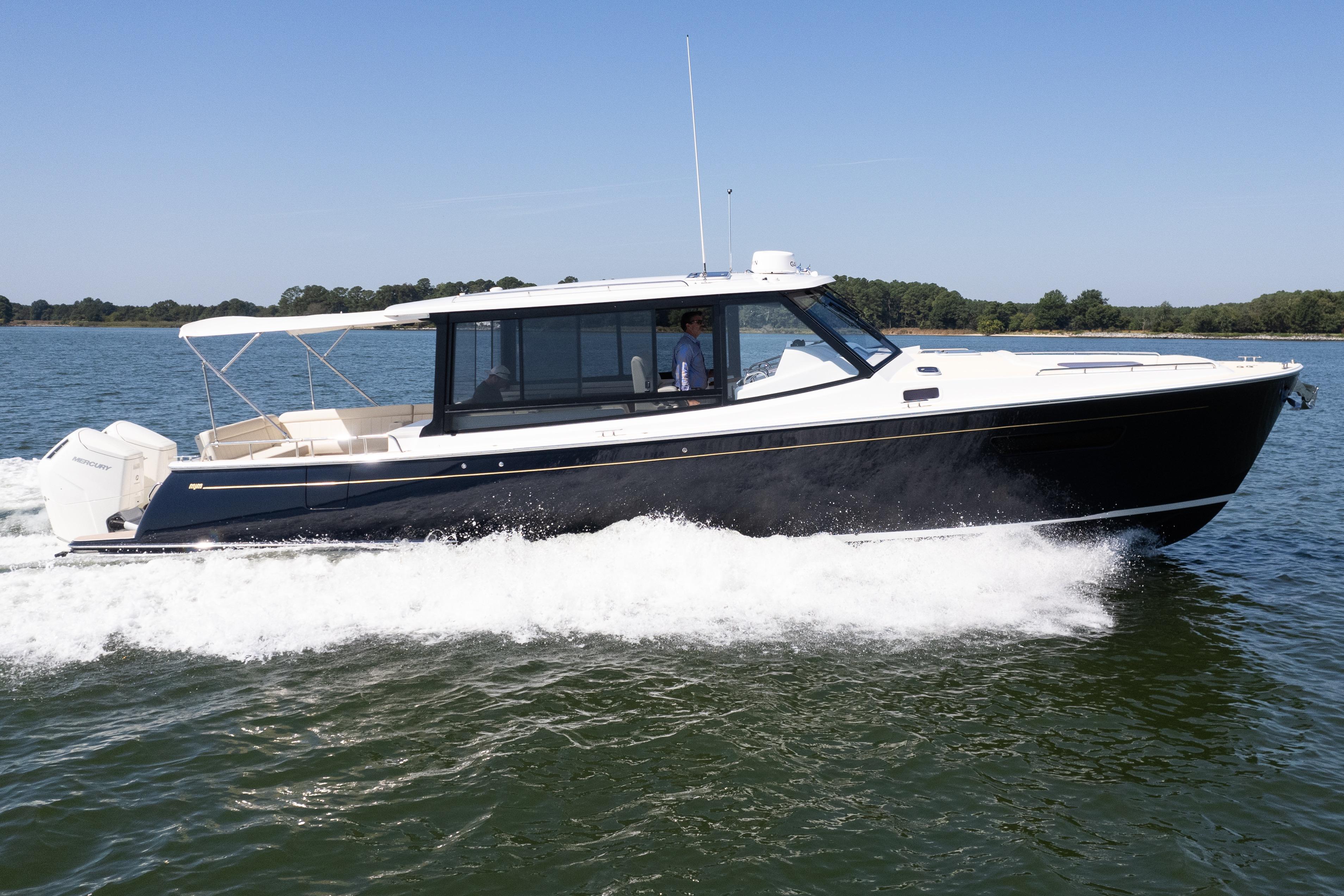 2023 MJM Yachts 4 cruising on water, sleek design, side view.