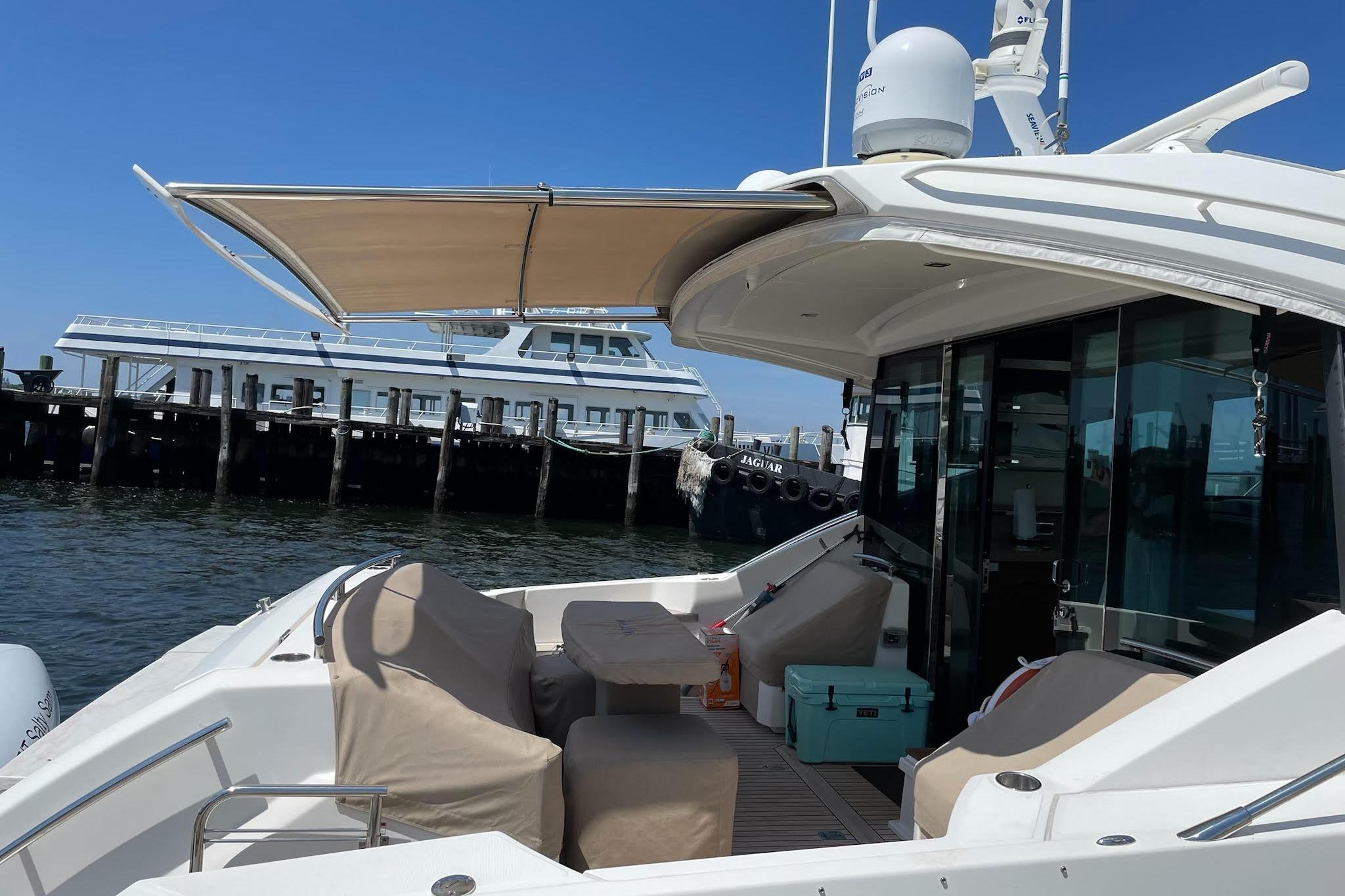2014 Tiara 5000 Coupe yacht docked, featuring a shaded deck and modern design.