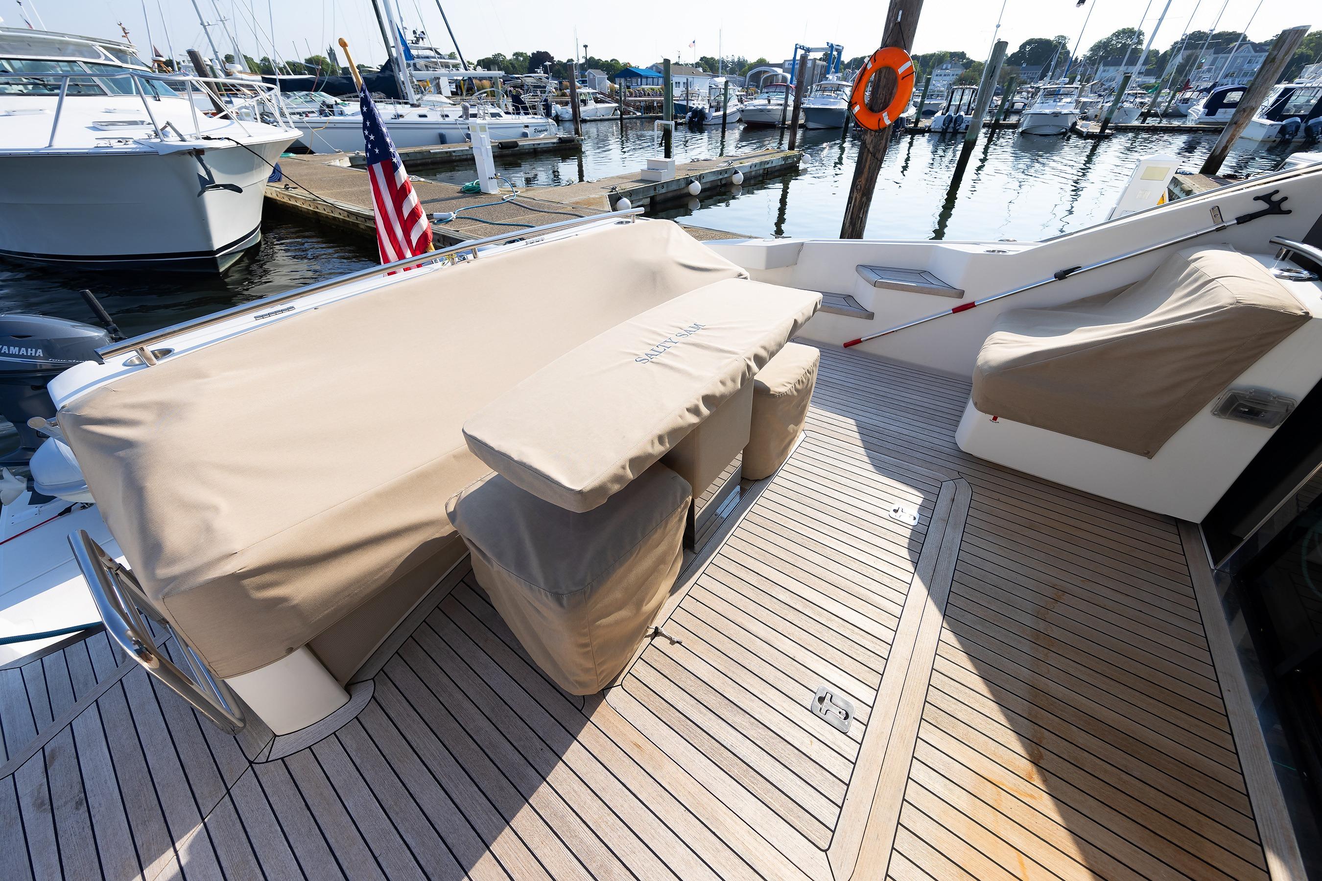 2014 Tiara 5000 Coupe yacht deck with covered seating at marina.